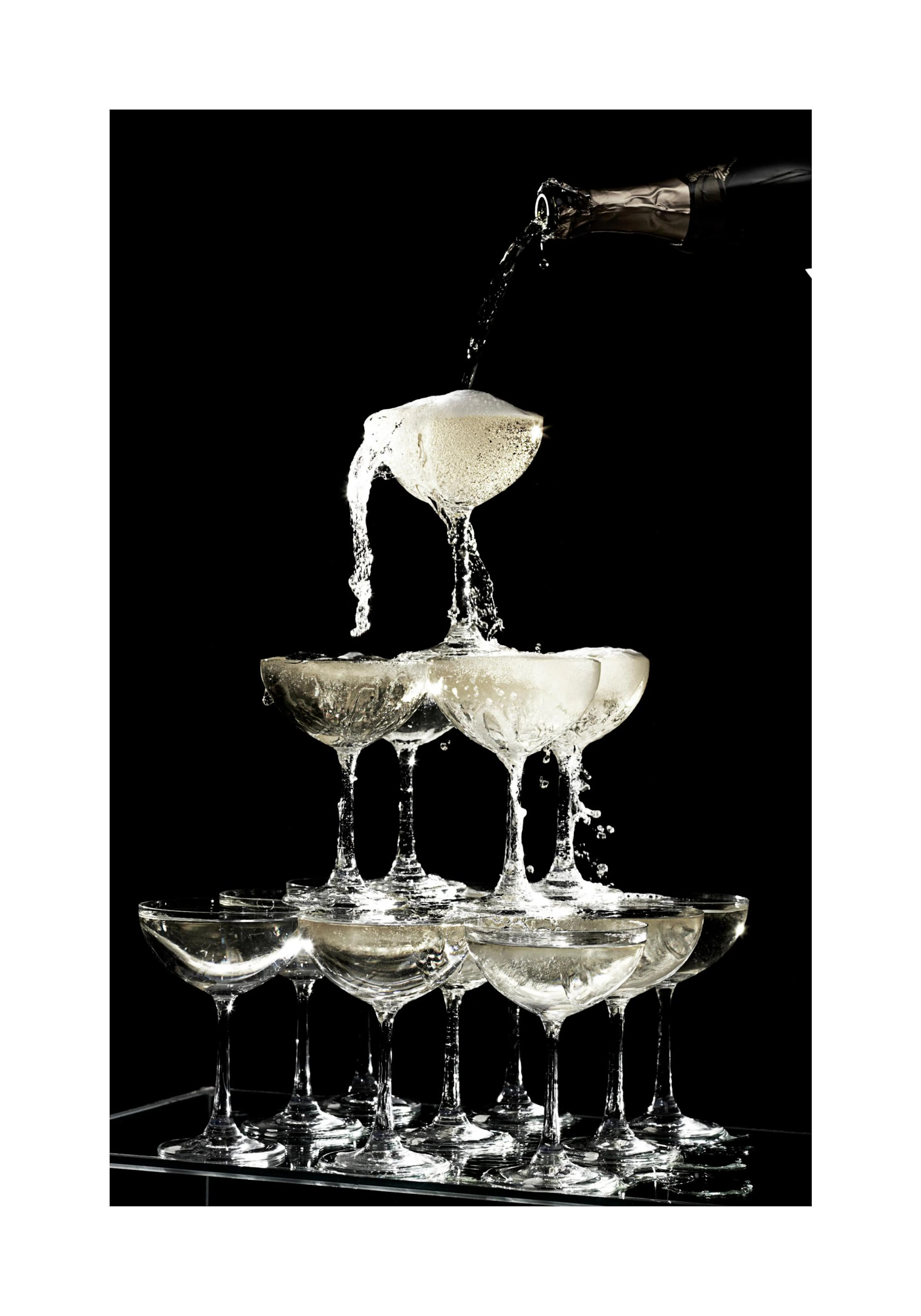 A poster depicting champagne pouring from a bottle into a tower of coupes, overflowing with bubbles and liquid.
