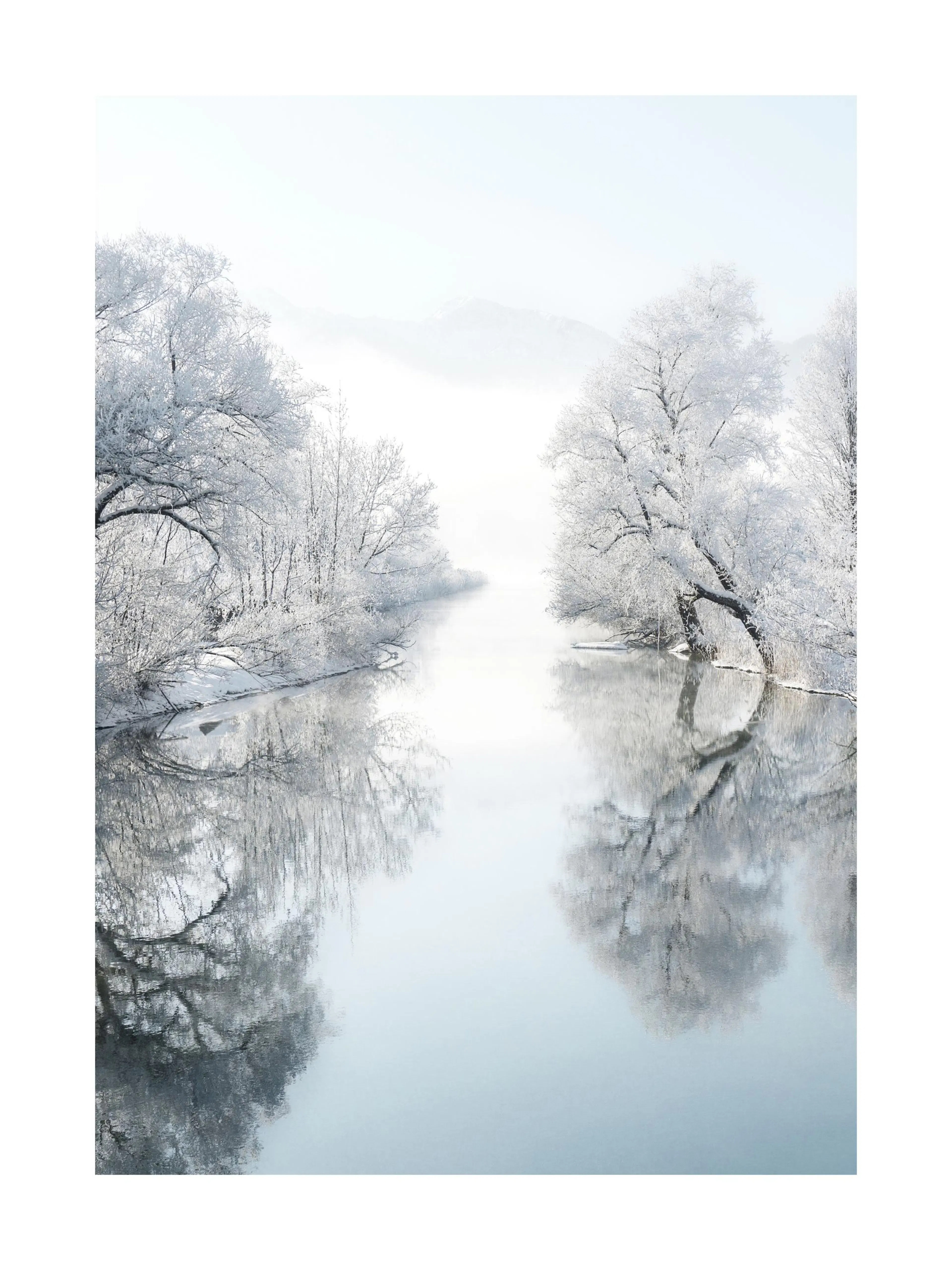 Een poster van een besneeuwde rivier in winterlandschap met bergen op de achtergrond en weerspiegeling in het water.