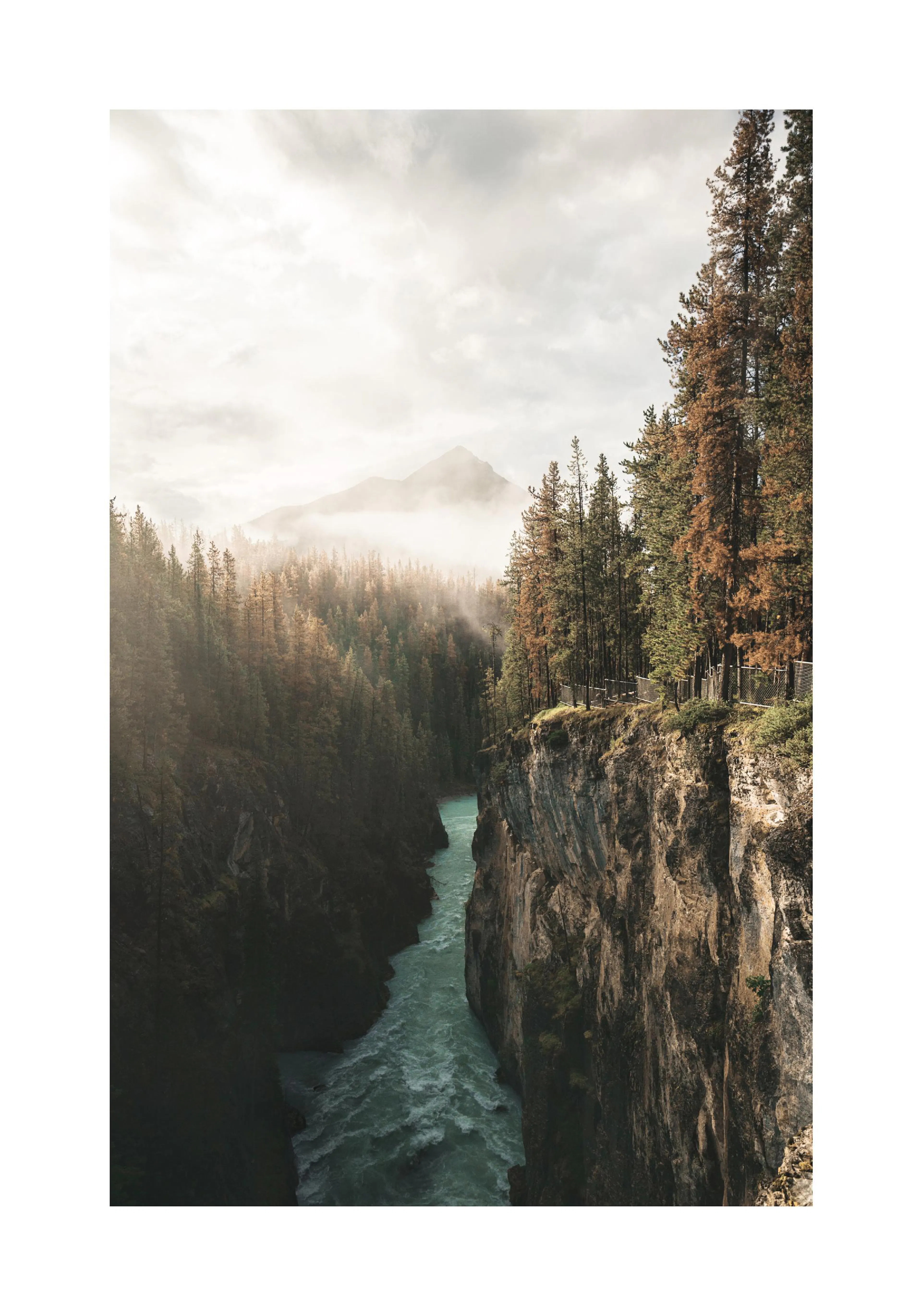 A poster featuring a vibrant turquoise river flowing through a deep canyon with rocky cliffs and pine trees under a cloudy sky.