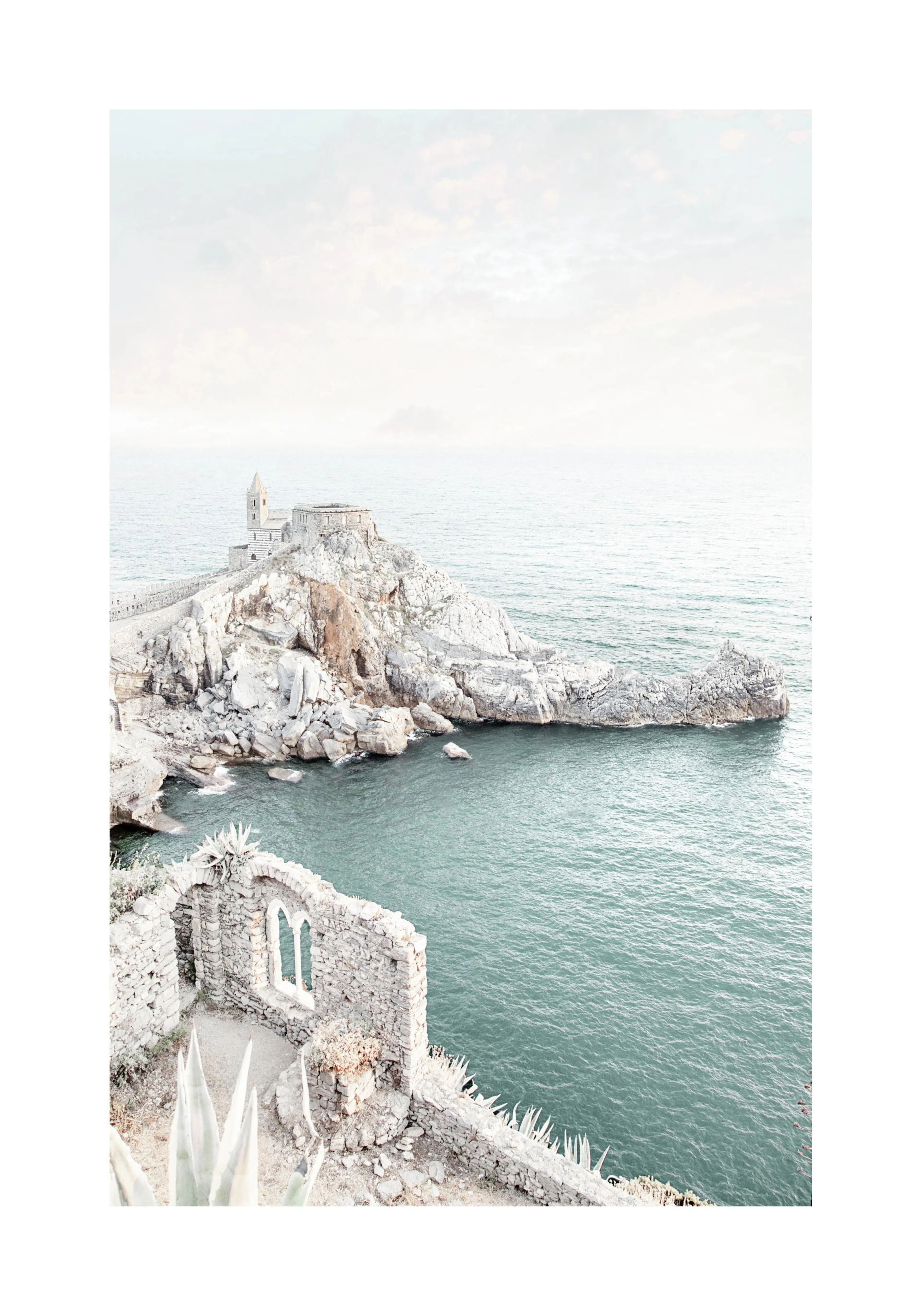 A poster featuring a high-angle view of a stone church on a rocky promontory overlooking the sea.