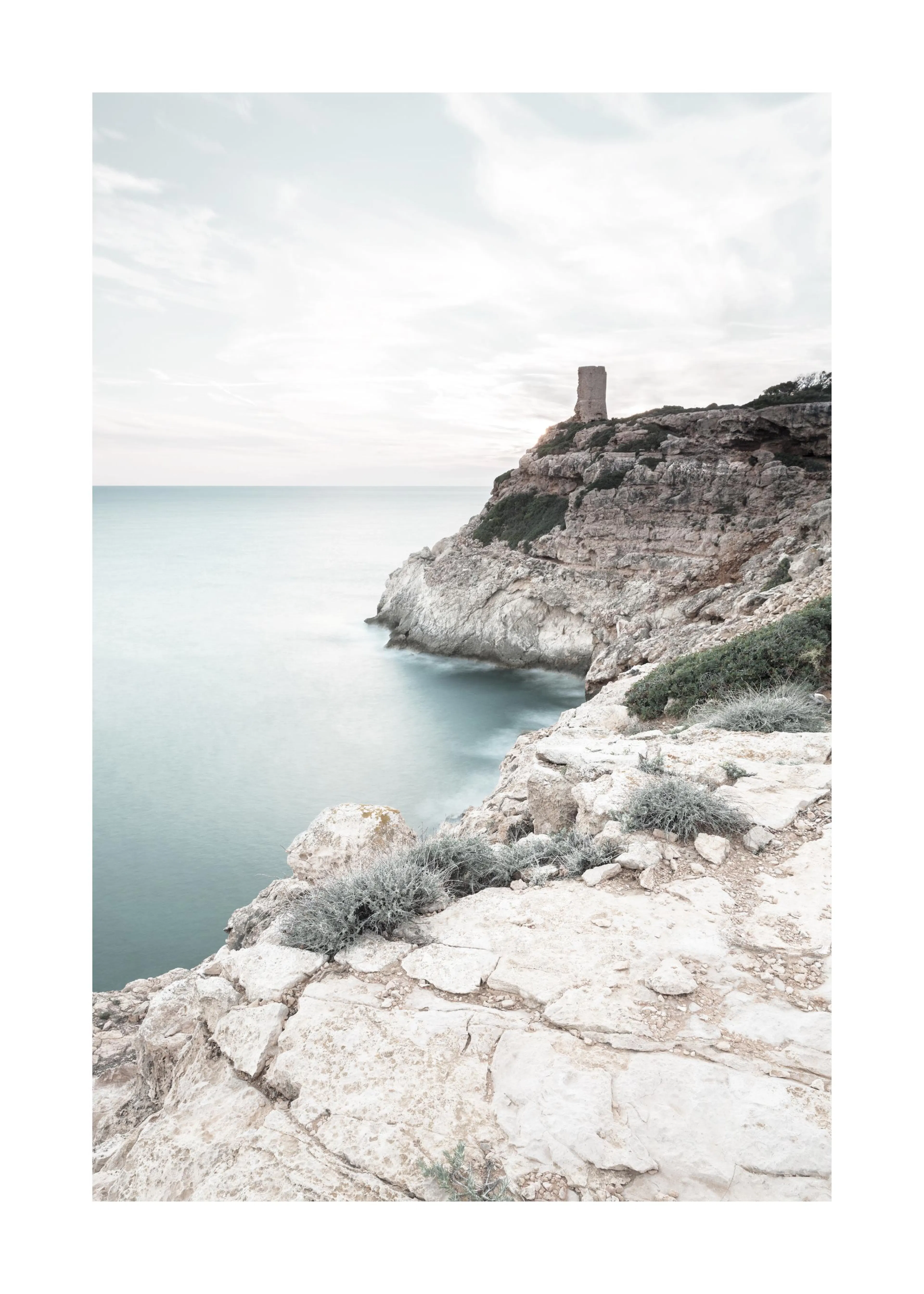 Poster einer felsigen Küstenlandschaft mit einem alten Turm auf dem Felsen und ruhigem, blaugrünem Meer unter hellgrauem Himmel.