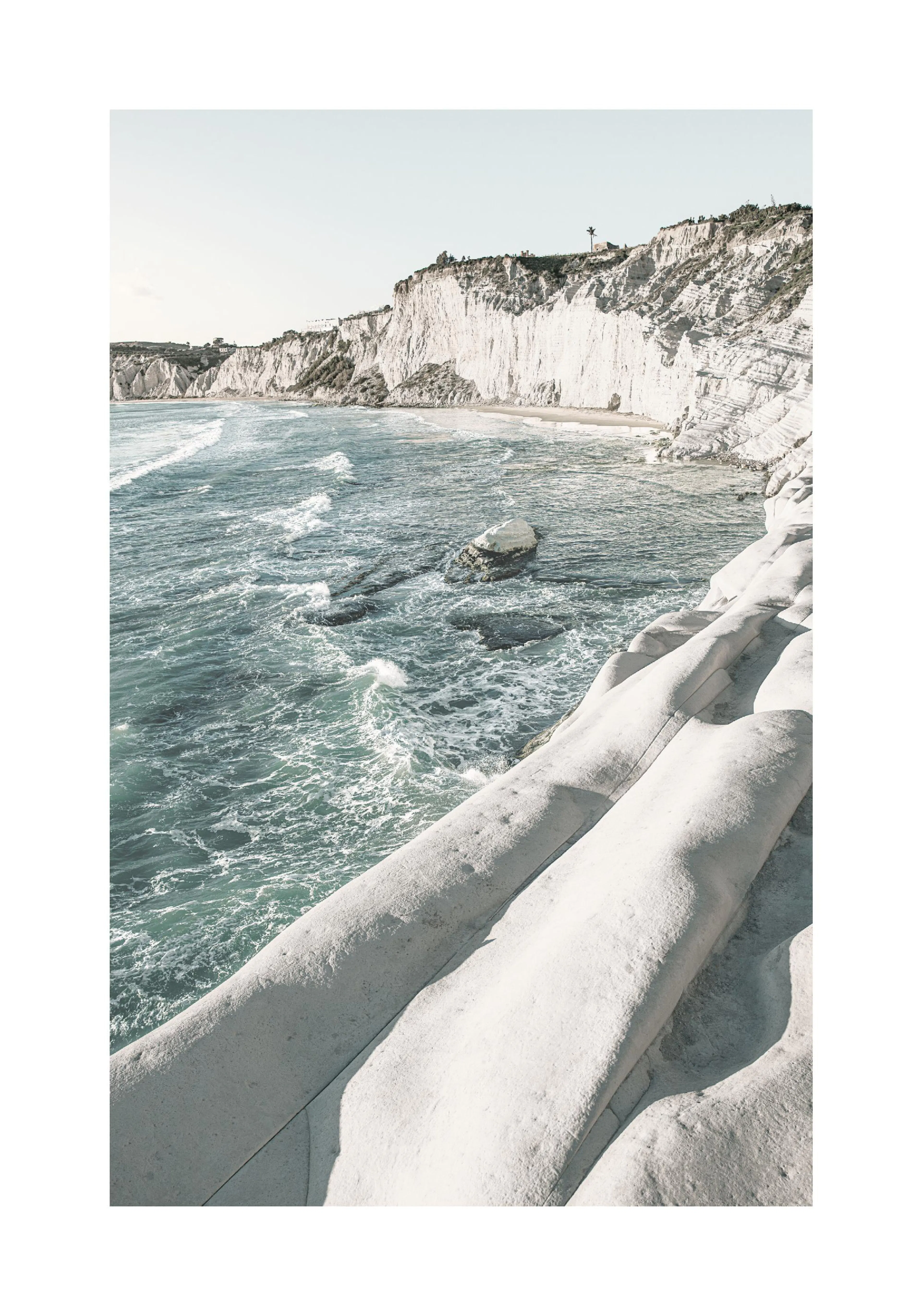 A poster featuring a coastal landscape with white cliffs and turquoise ocean waves, seen from above.