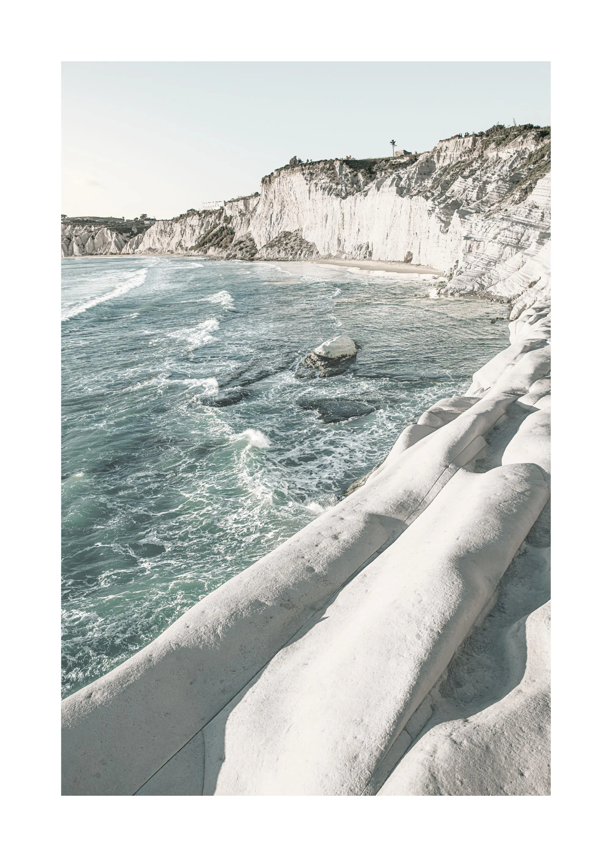 Poster einer felsigen Küstenlandschaft mit weißer Felsformation im Vordergrund und türkisfarbenem Meer.