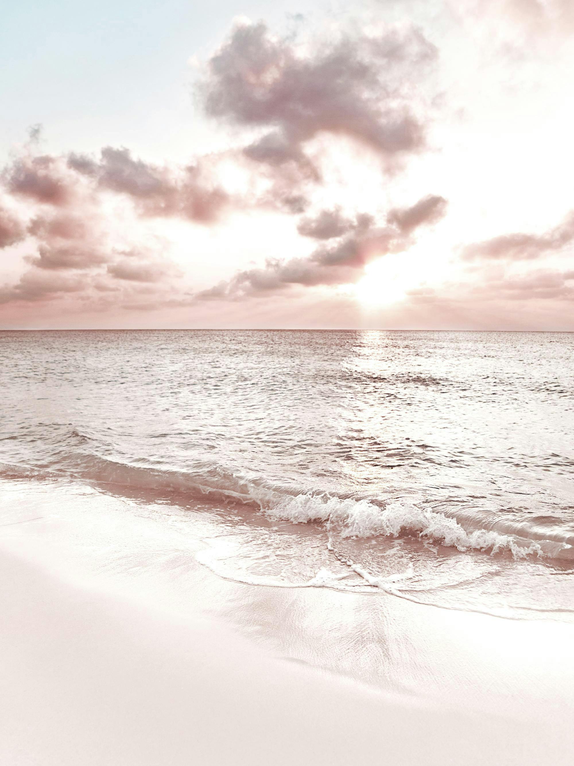 A poster depicting a serene beach scene at sunset with soft pink and blue hues in the sky and calm water.