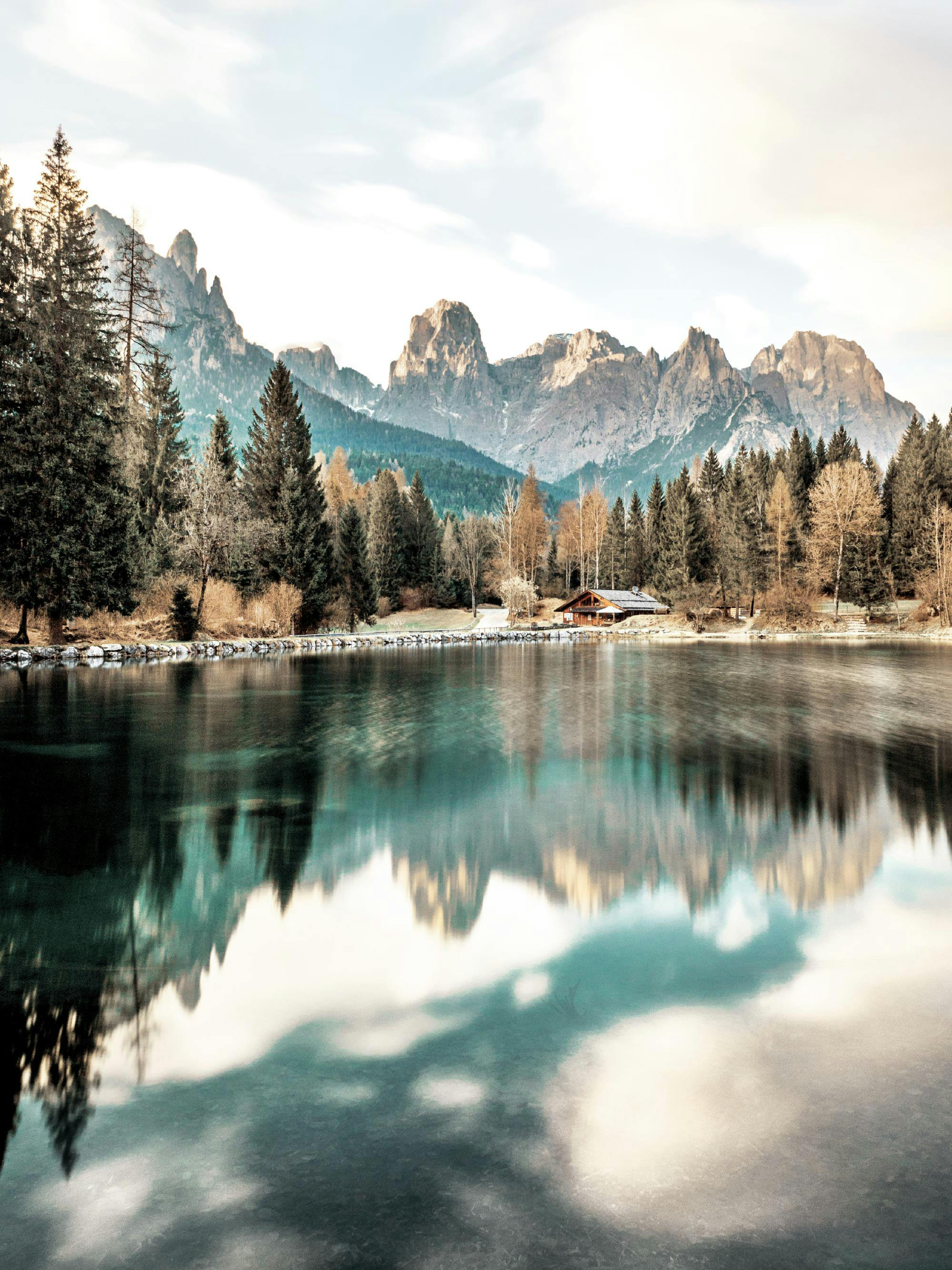 A poster featuring a tranquil lake scene with snow-capped mountains and evergreen trees reflecting on the water.