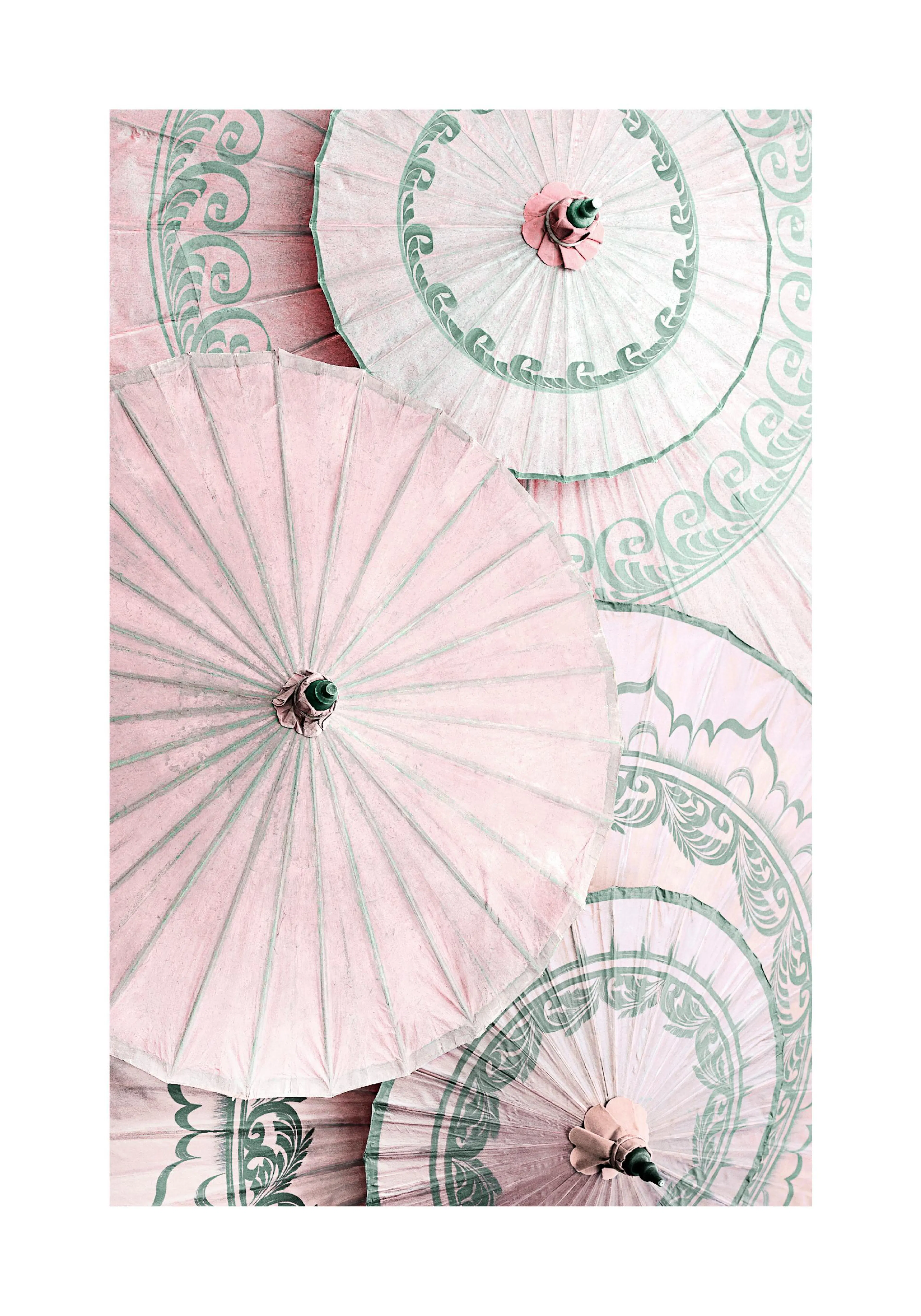 A poster featuring a close-up of pink and mint green patterned paper parasols in an overlapping arrangement.
