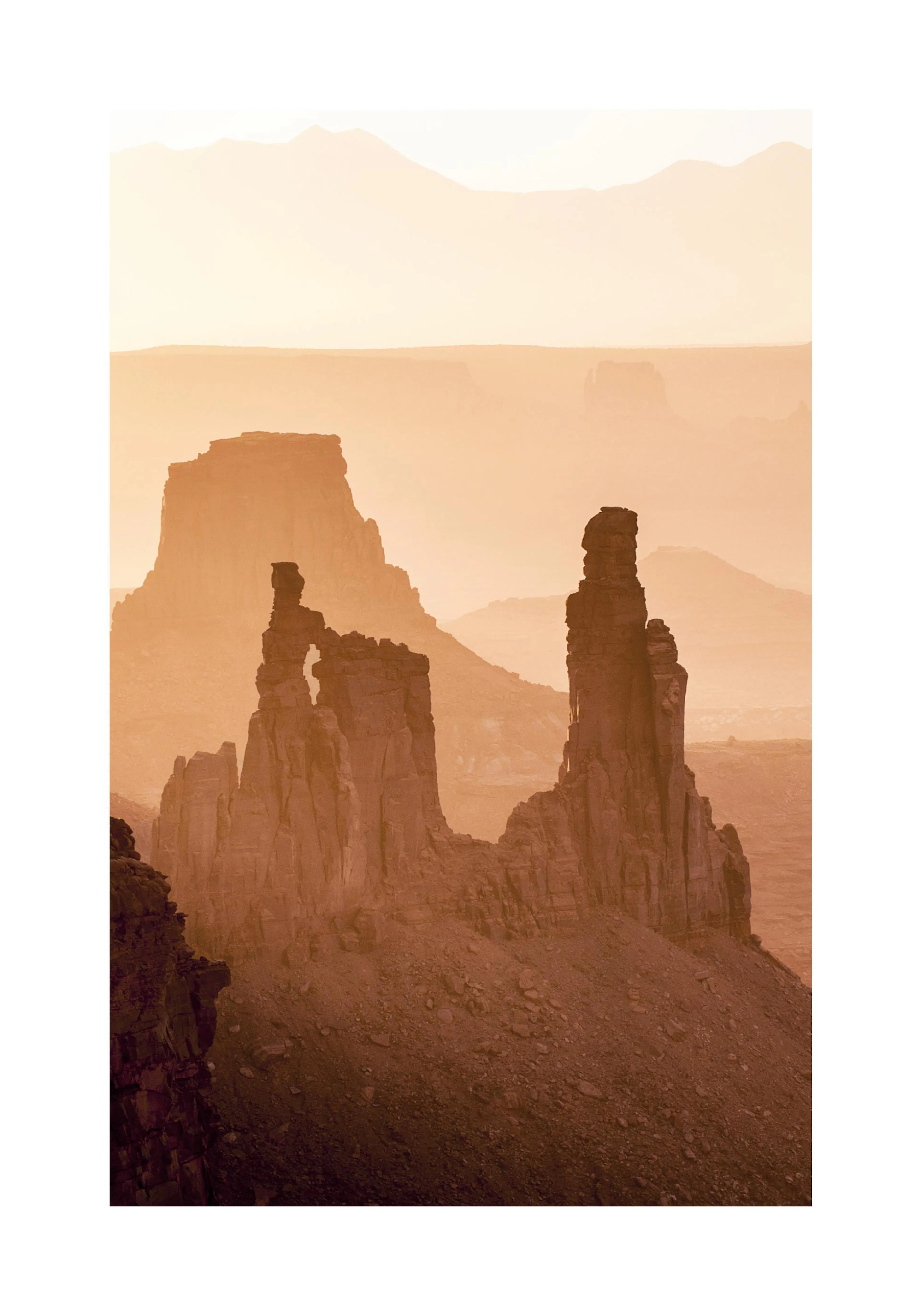 A poster depicting a desert landscape with large, weathered rock formations under a hazy, orange sky.