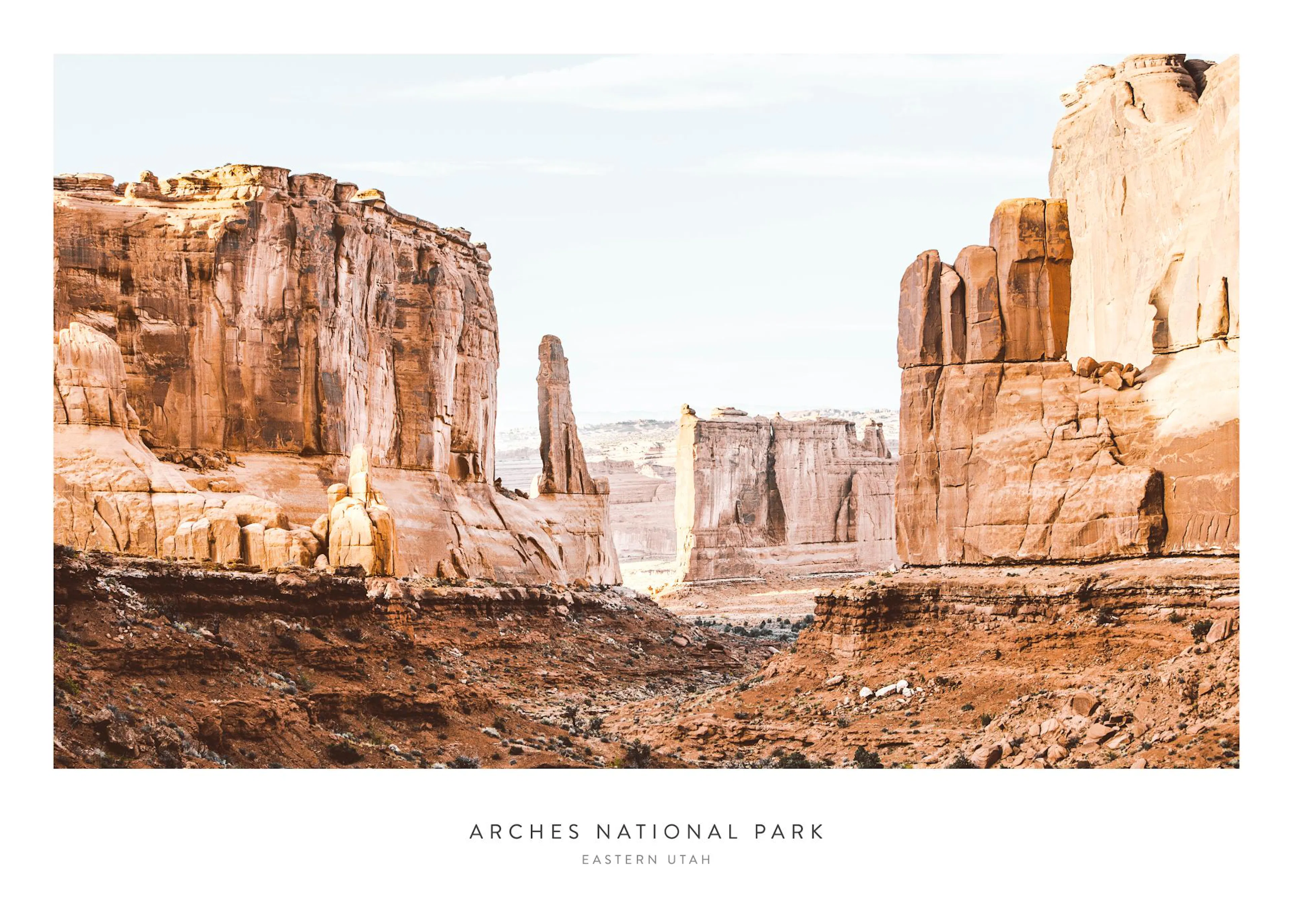 En poster som visar de distinkta röda klippformationerna i Arches National Park, Utah, under en ljus himmel.