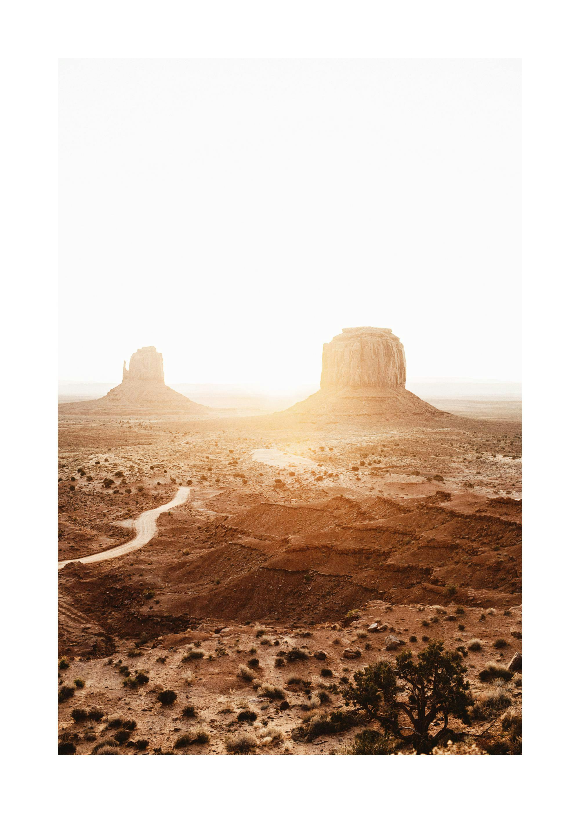 Poster du désert de Monument Valley au coucher du soleil, avec deux buttes et une route sinueuse.