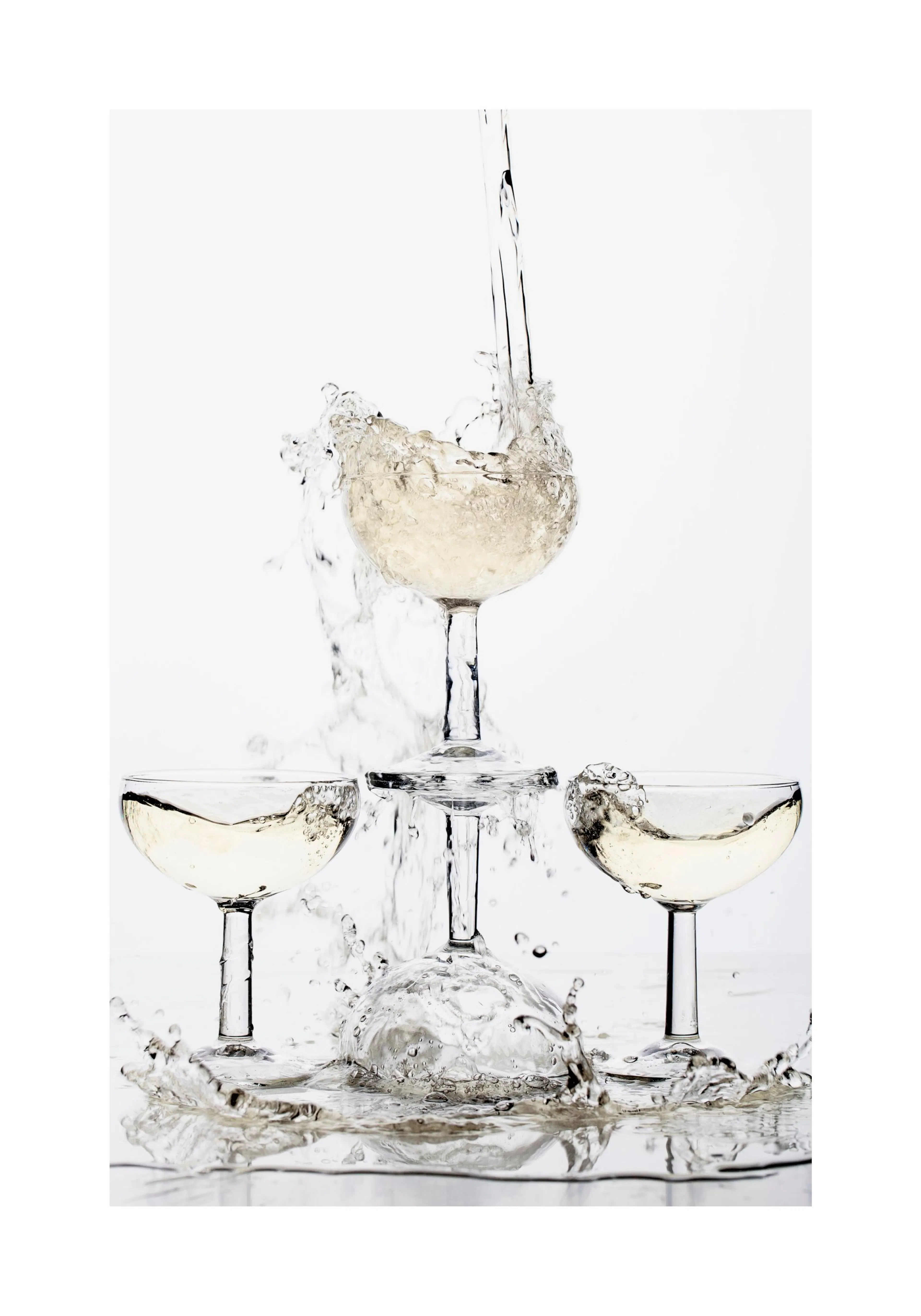 A poster featuring a stack of four champagne glasses, with liquid splashing dynamically from the top glass.