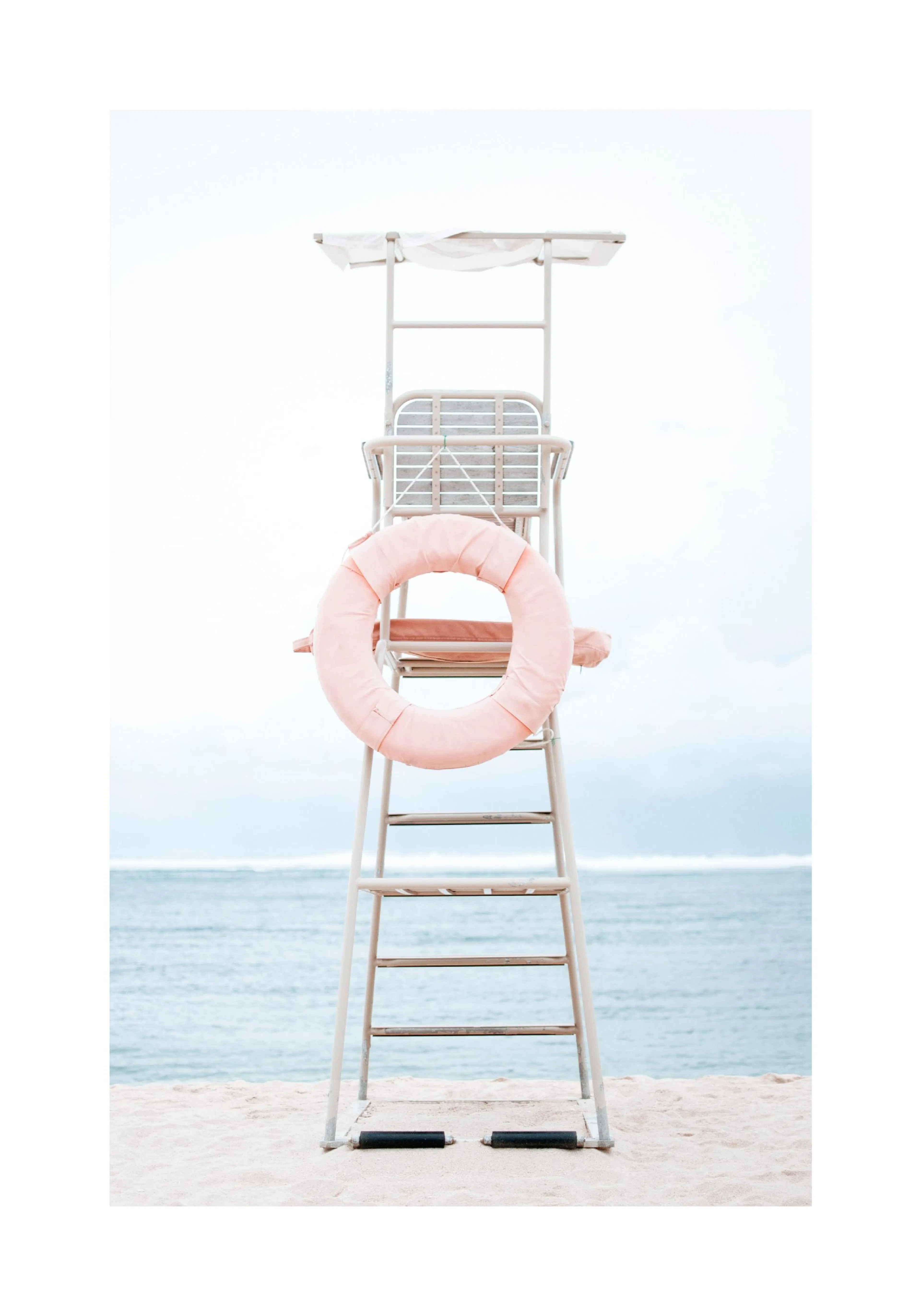 A poster of a lifeguard chair with a pink life buoy on a sandy beach with blue ocean and sky.