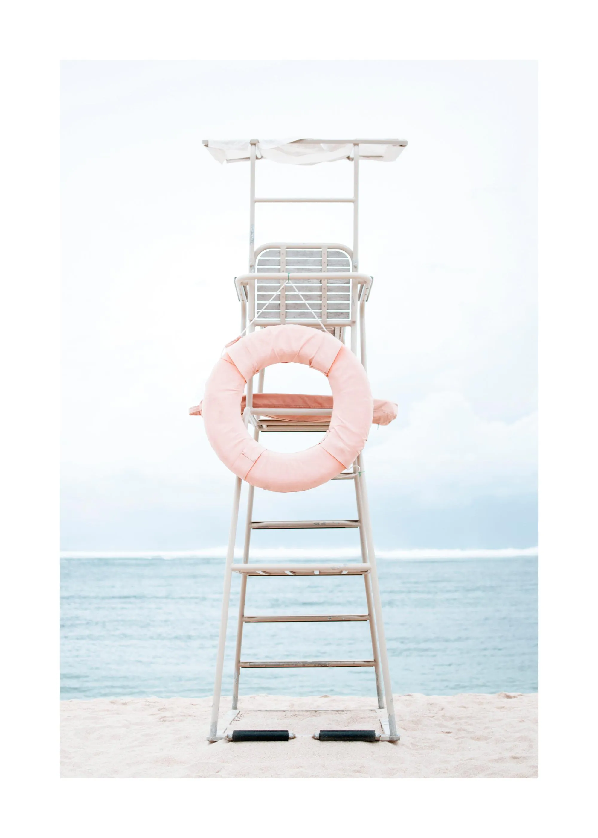 A poster featuring a white lifeguard tower with a pink life preserver on a sandy beach, with the ocean in the background.