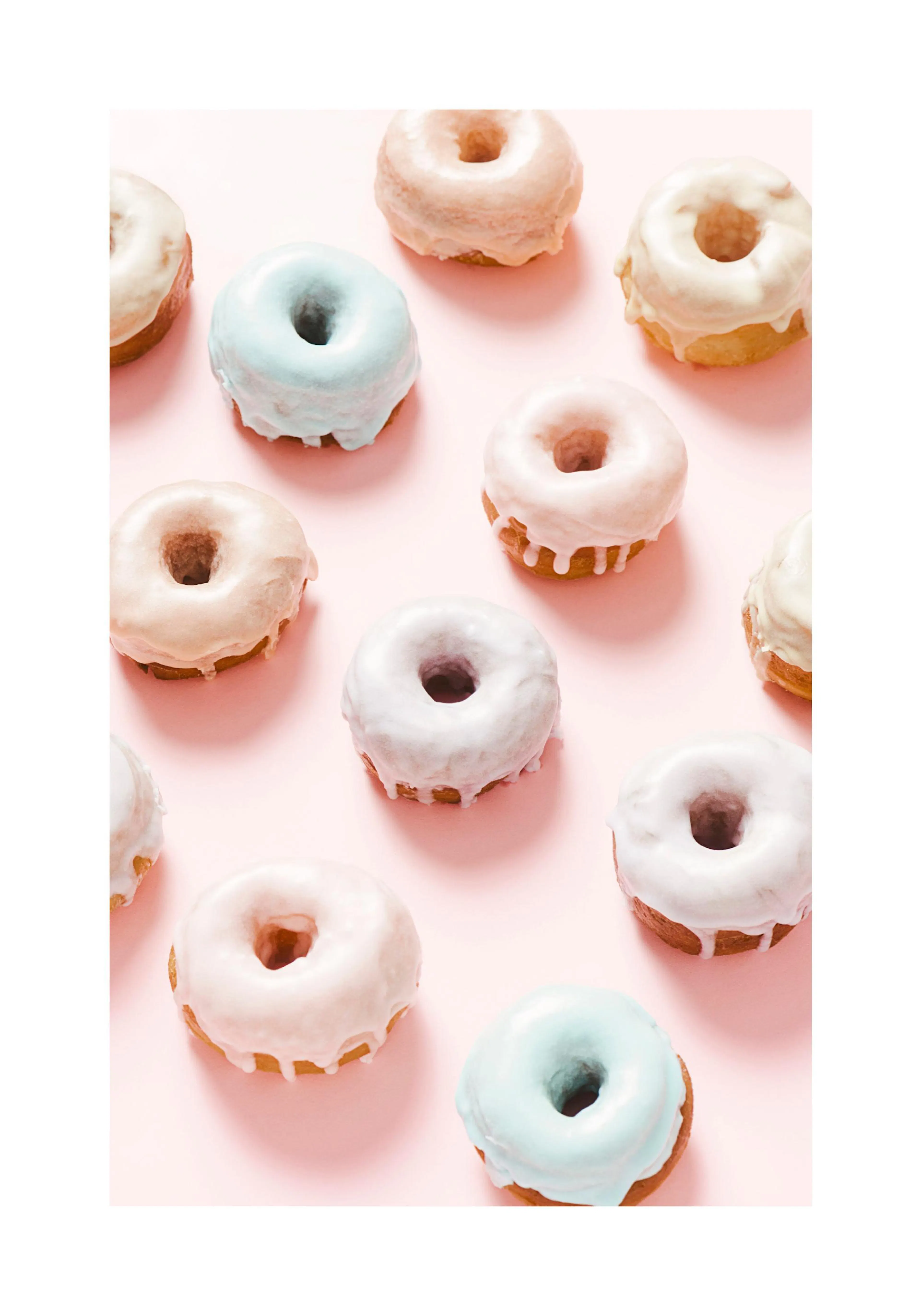 A poster featuring a top-down view of several pastel-coloured donuts with icing on a pink background.