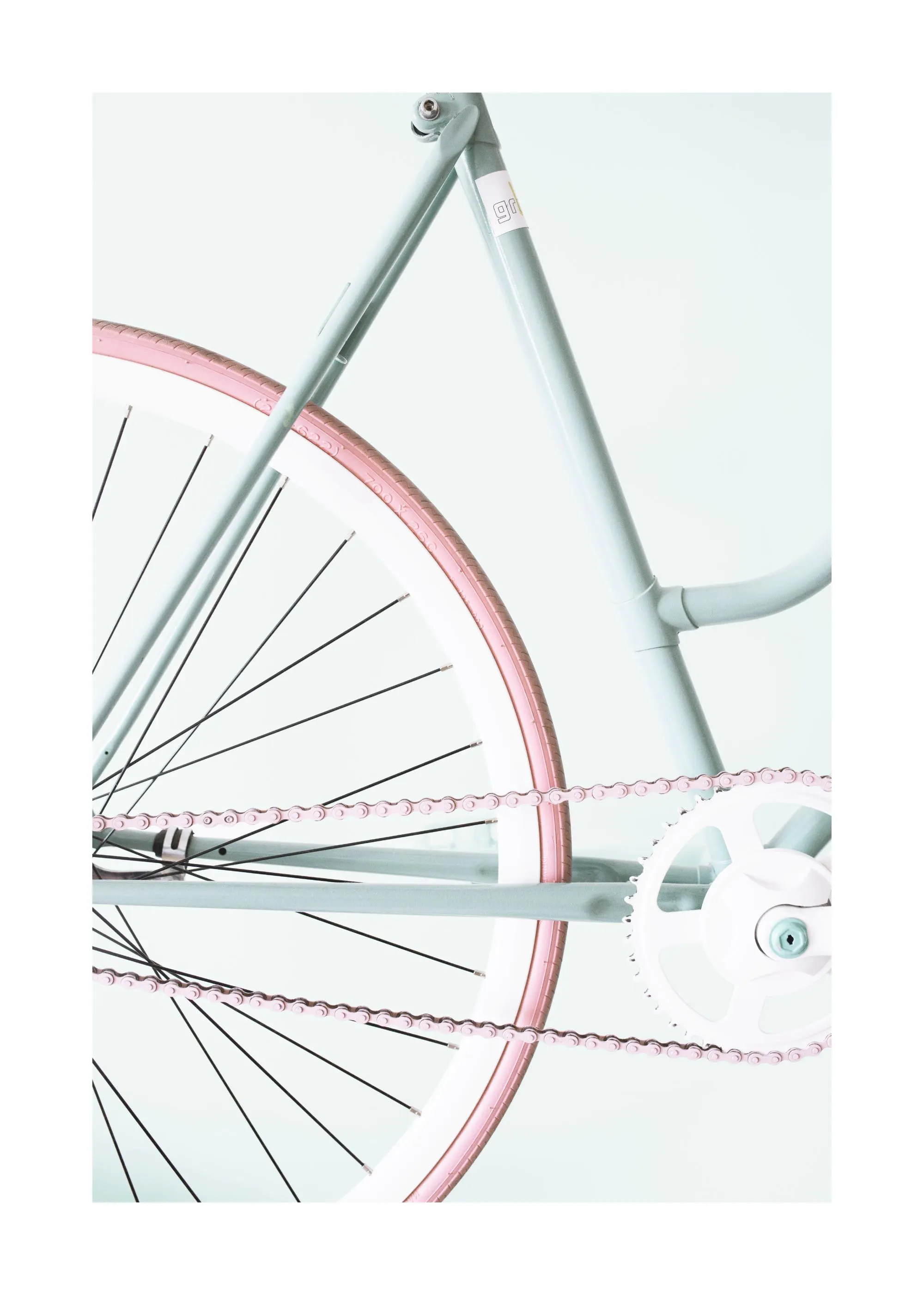 Poster van een minimalistische mintgroene fiets met roze banden en ketting, op een lichte achtergrond.