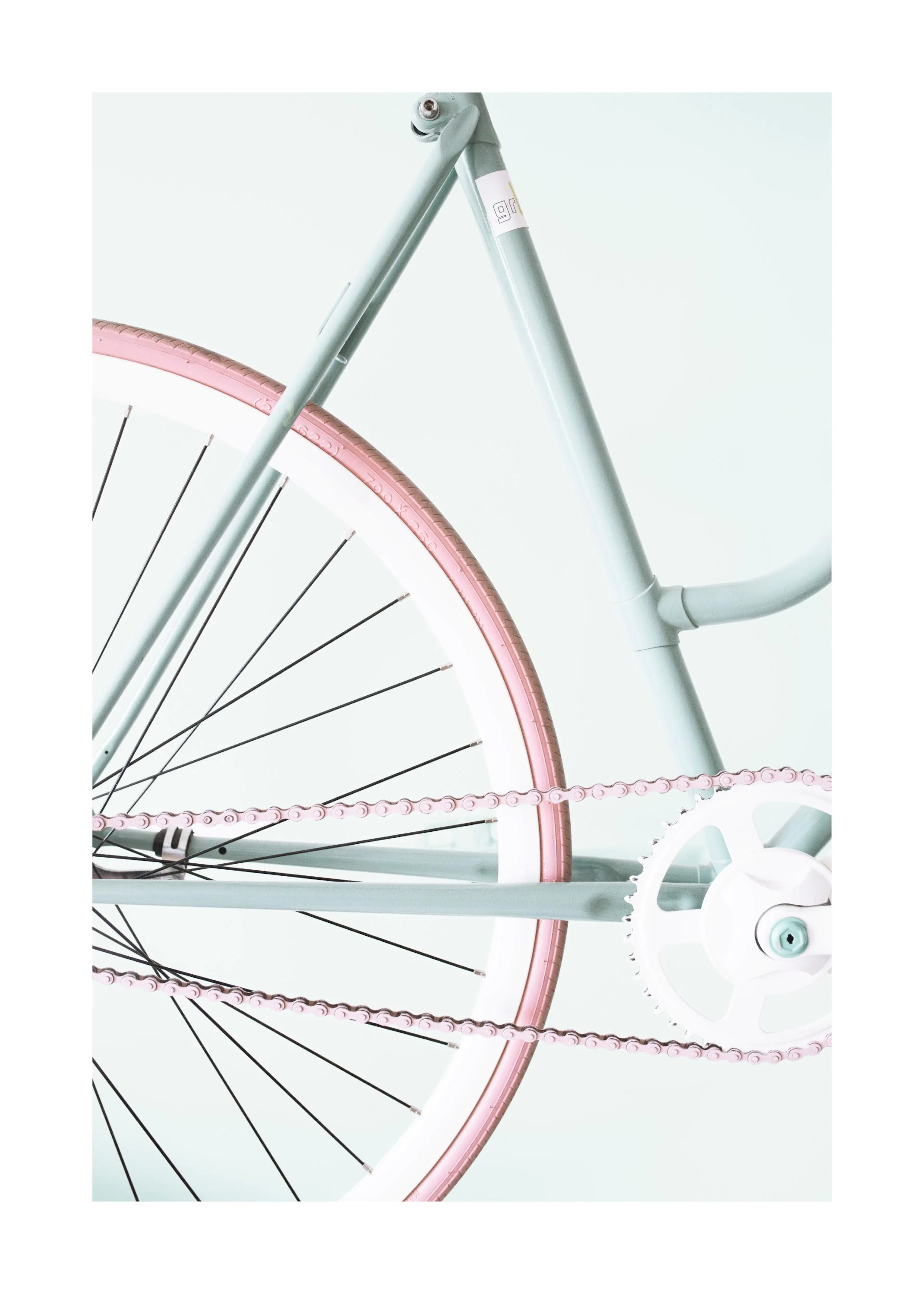Póster de una bicicleta de piñón fijo en tonos pastel, con cuadro azul verdoso y neumáticos rosa claro.