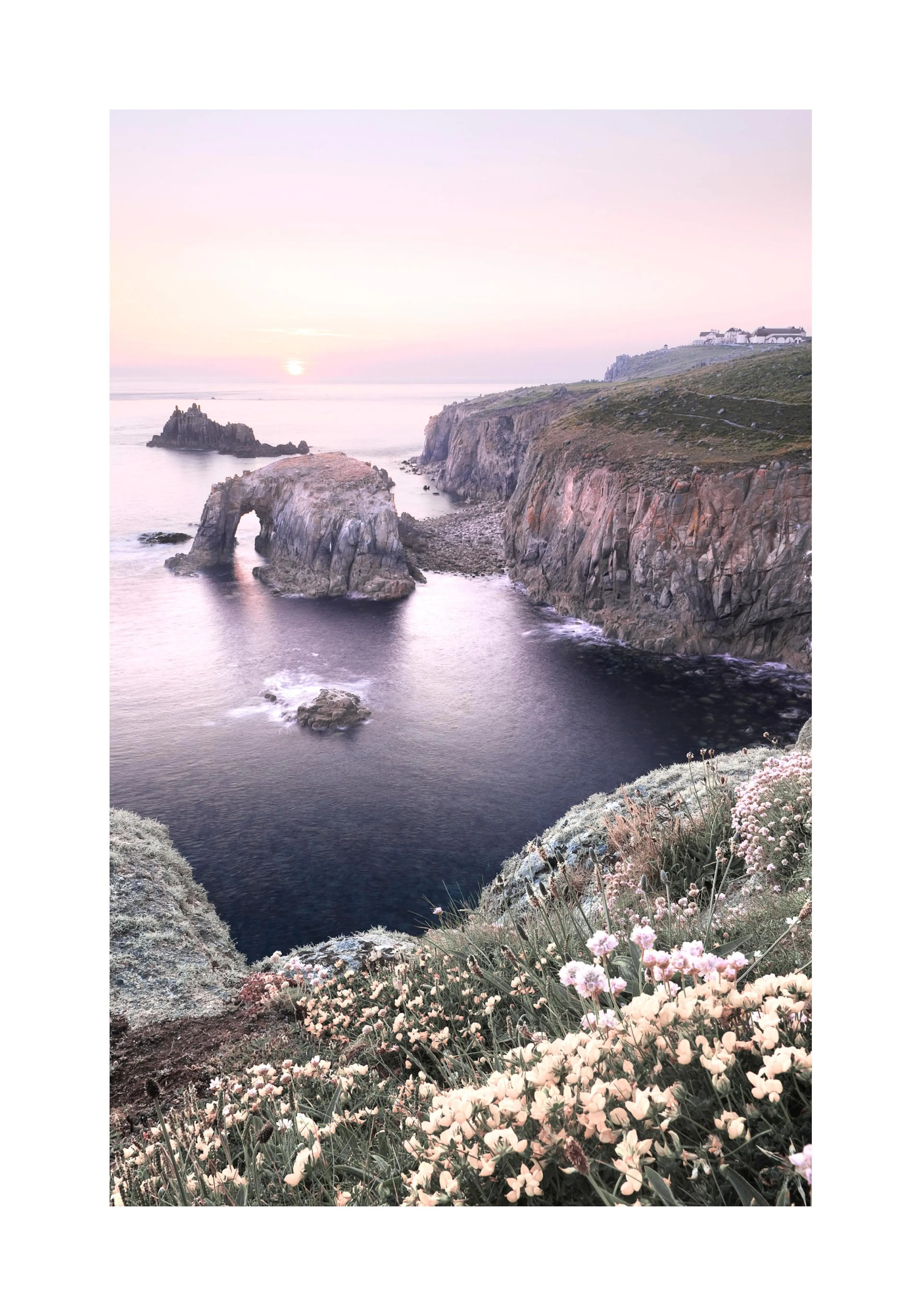 A poster depicting a rugged coastline with a natural rock arch, calm ocean waters, and a sunset over the horizon.