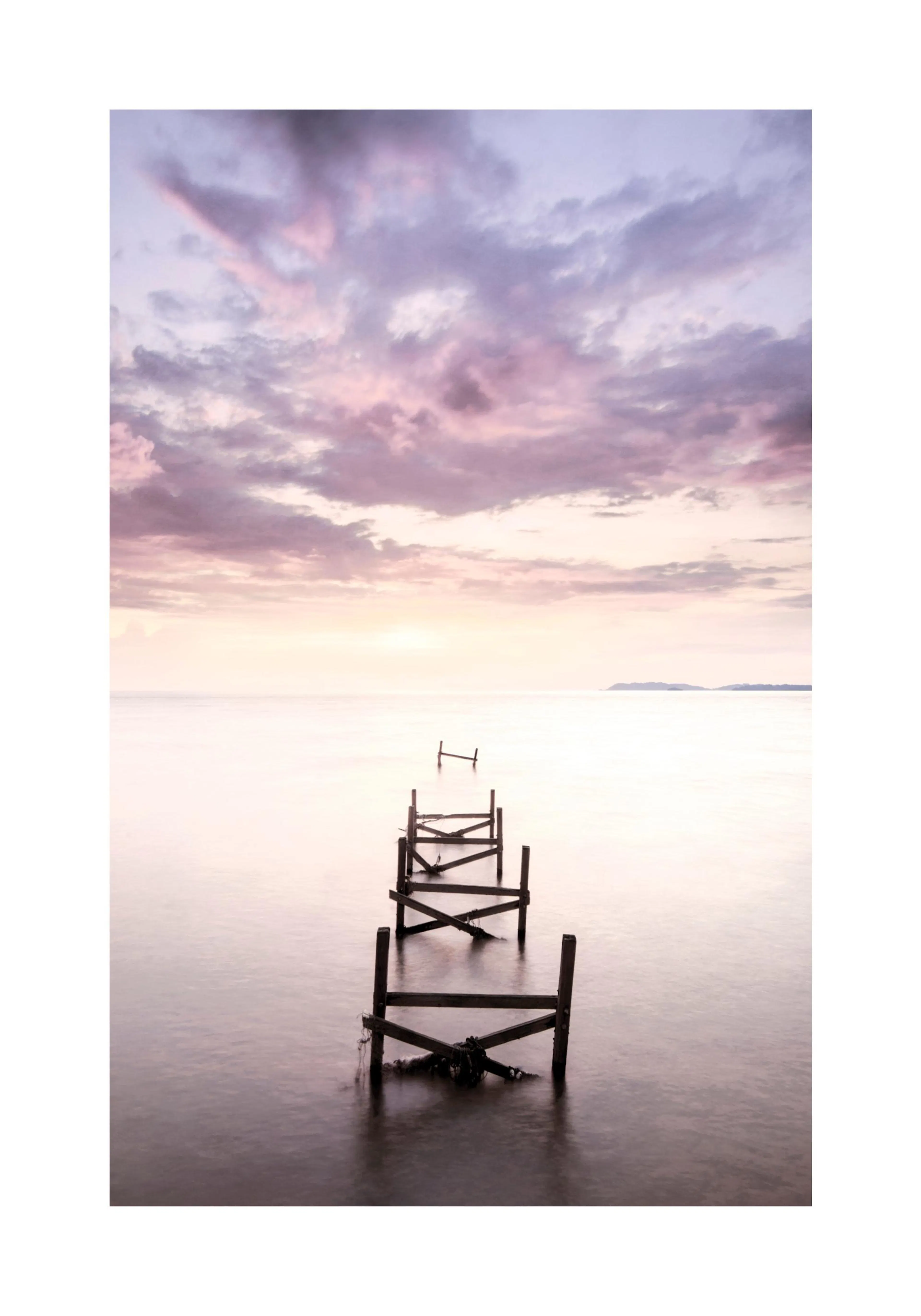 A poster featuring an old, broken wooden pier extending into calm water under a pastel pink and purple sunset sky.