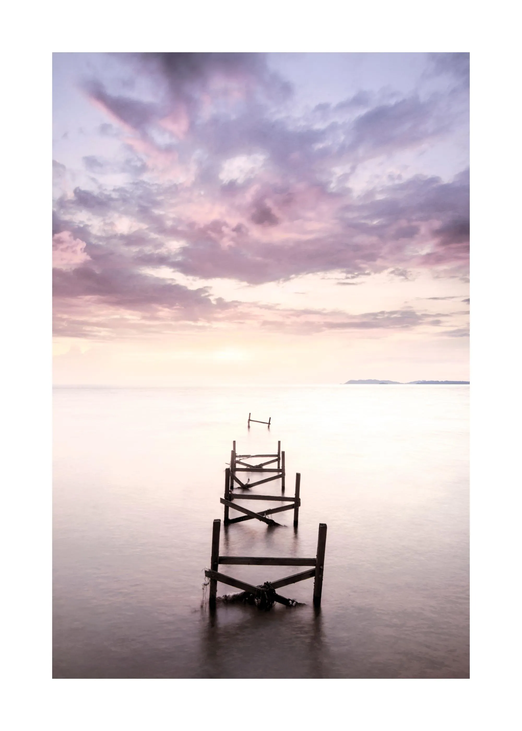 Poster eines alten Holzanlegers im Meer bei Sonnenuntergang mit lila Wolken und ruhigem Wasser.