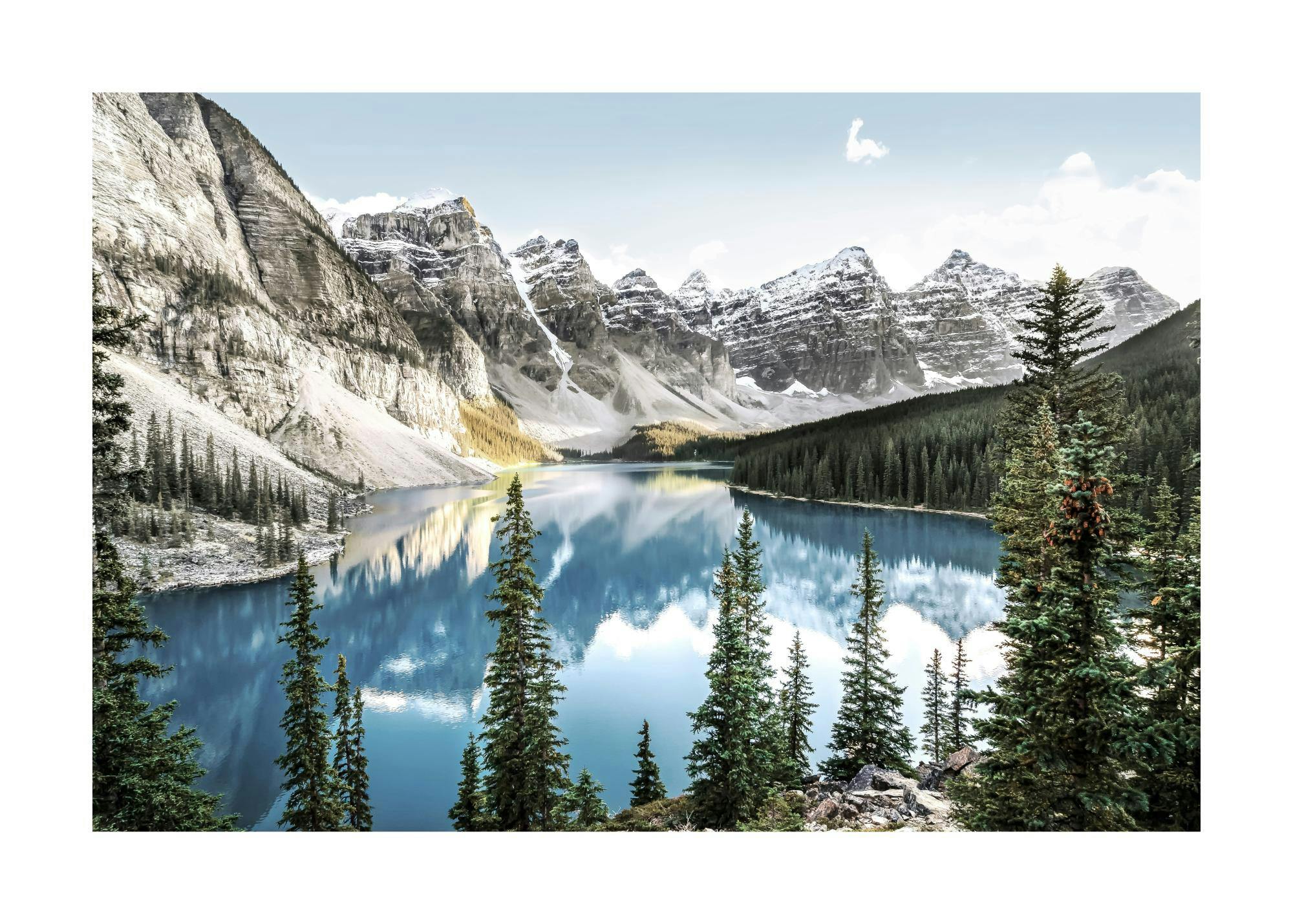 Póster de un lago azul rodeado de montañas rocosas cubiertas de nieve y un denso bosque de pinos, bajo un cielo claro con nubes.