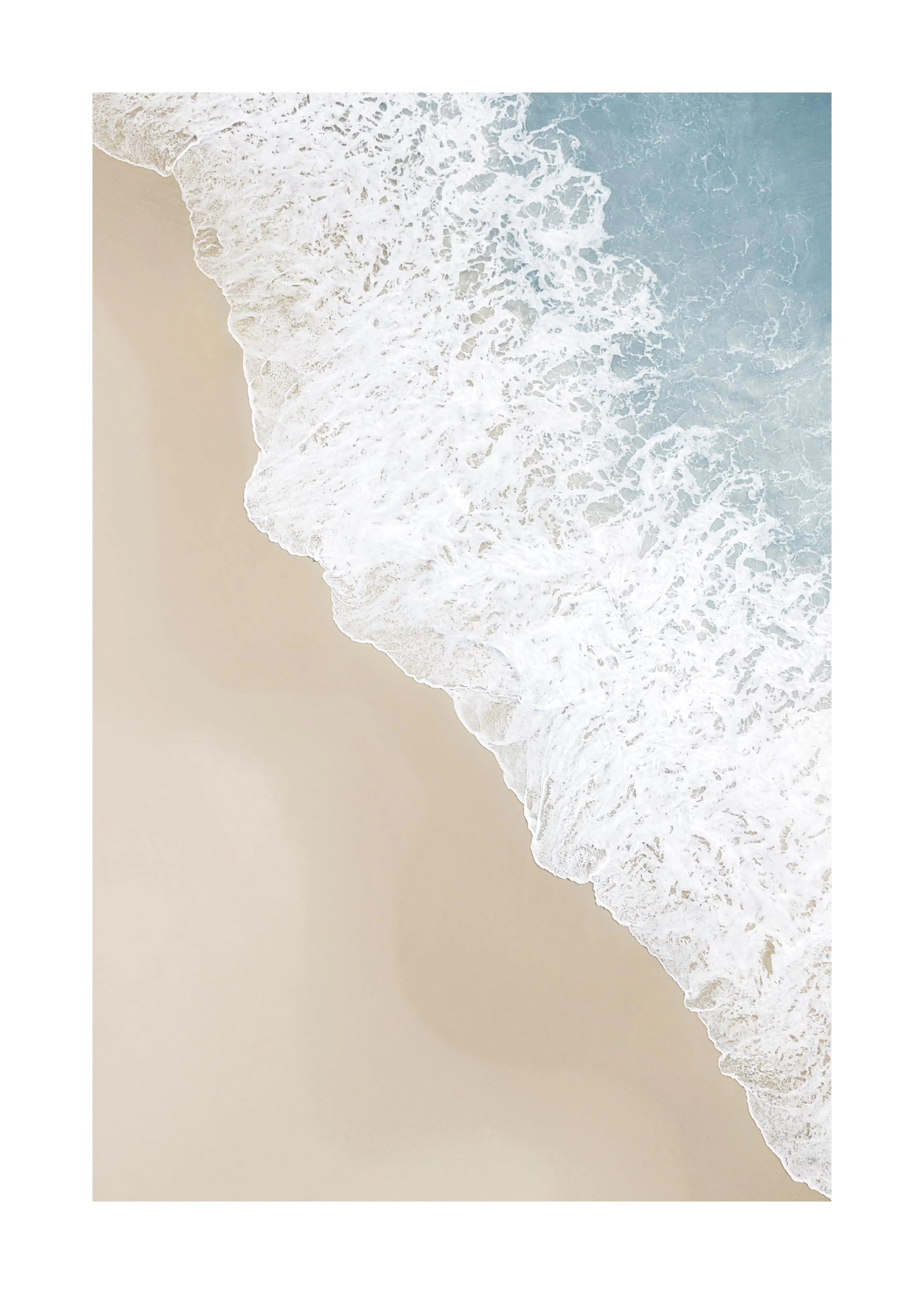 Poster: Strandansicht von oben mit beigefarbenem Sand und einer blauen Meereswelle mit weißem Schaum.
