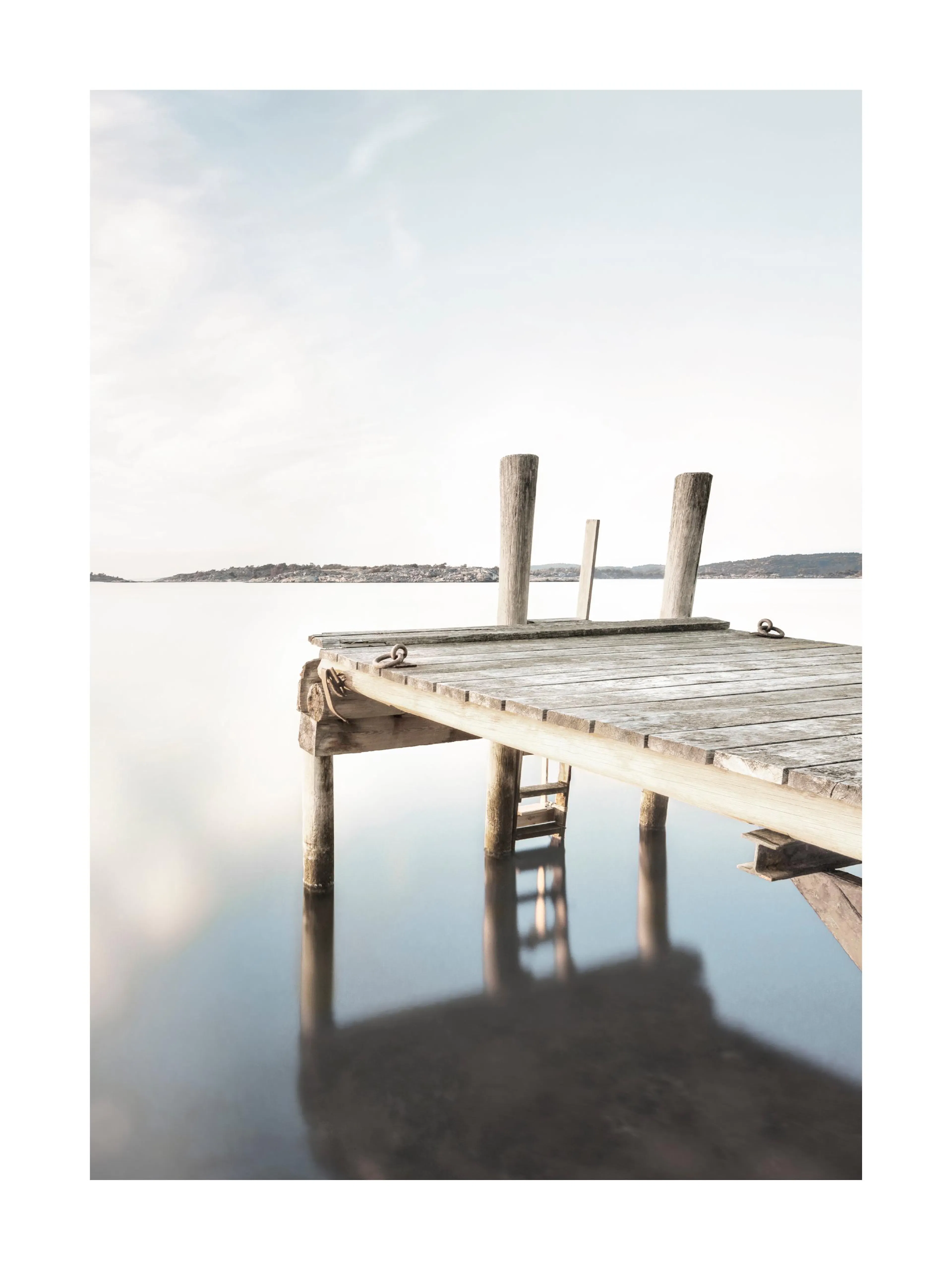 Póster de un muelle de madera rústico sobre un lago tranquilo con reflejos, bajo un cielo pálido.