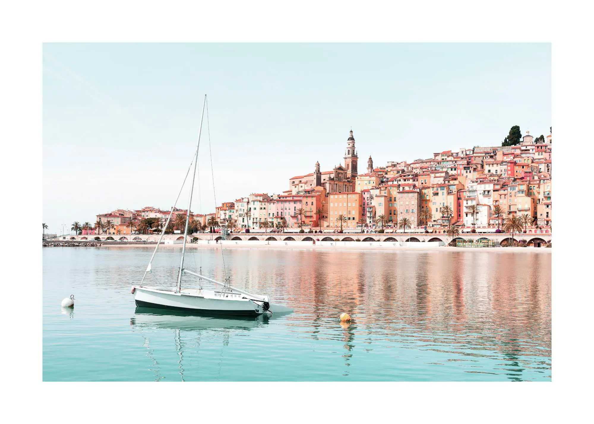 A poster featuring a white sailboat on turquoise water with a colourful coastal town and palm trees reflecting in the distance.