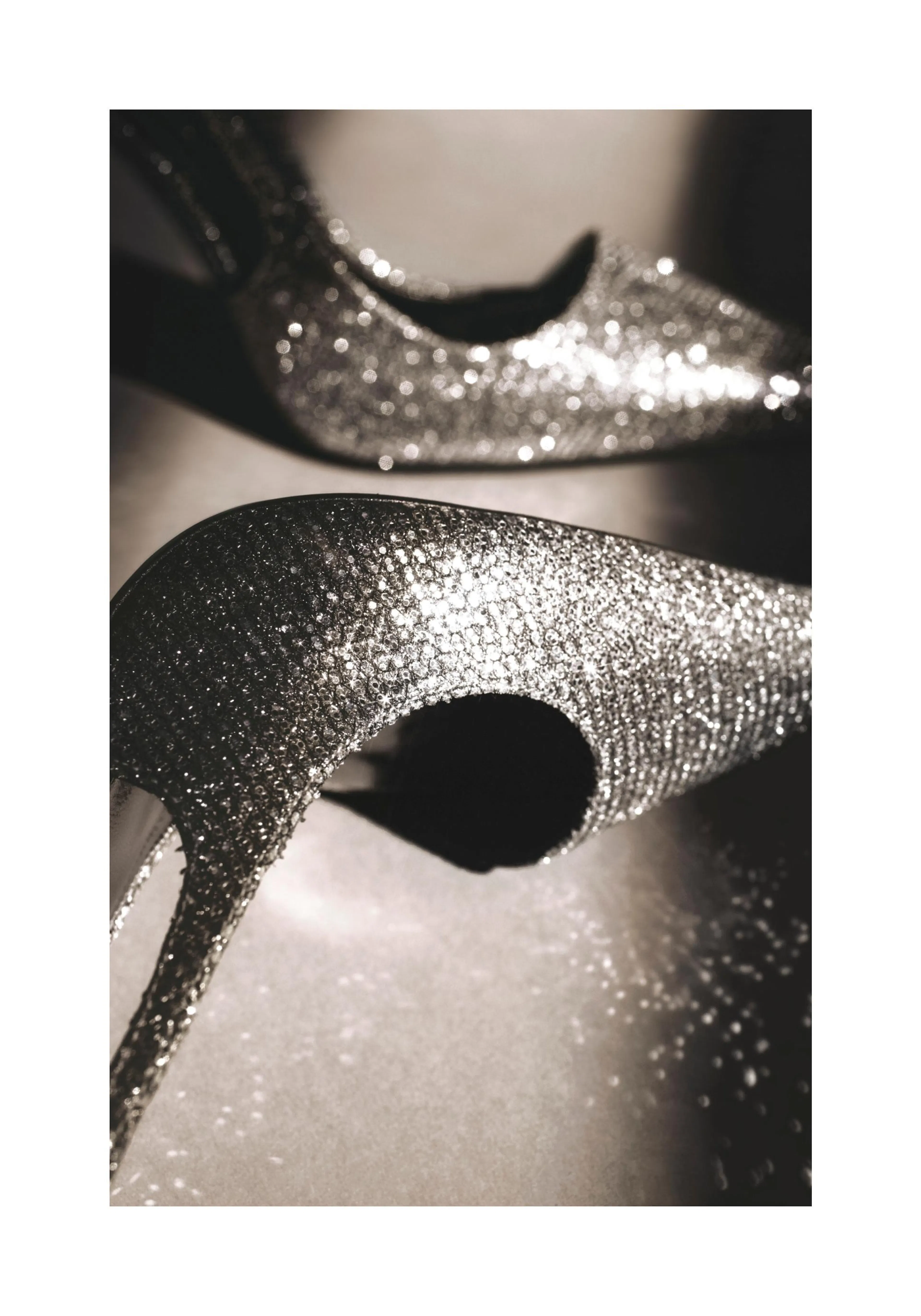 A poster featuring a close-up of two sparkling silver high-heel shoes with dark shadows, creating a luxurious feel.