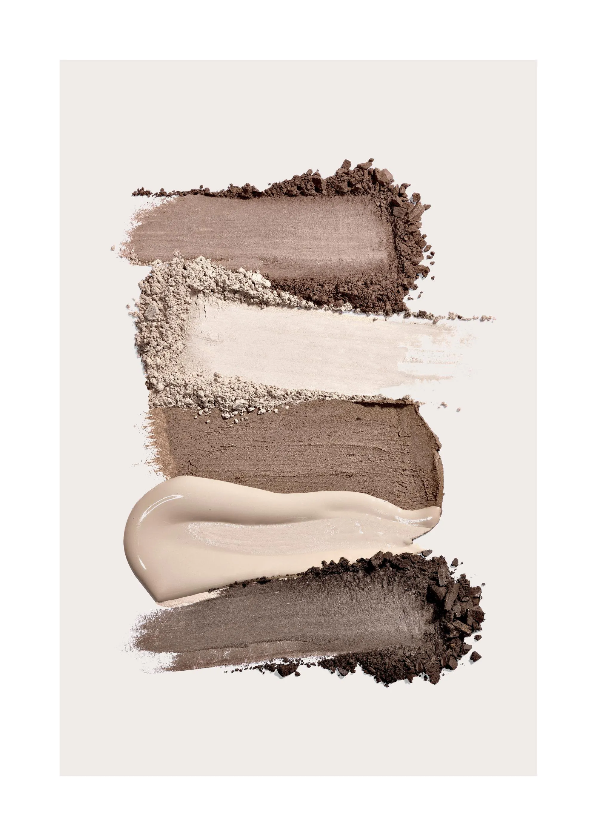 Een poster met vegen van beige en bruine make-up poeder, met een crème veeg en losse korrels op een witte achtergrond.