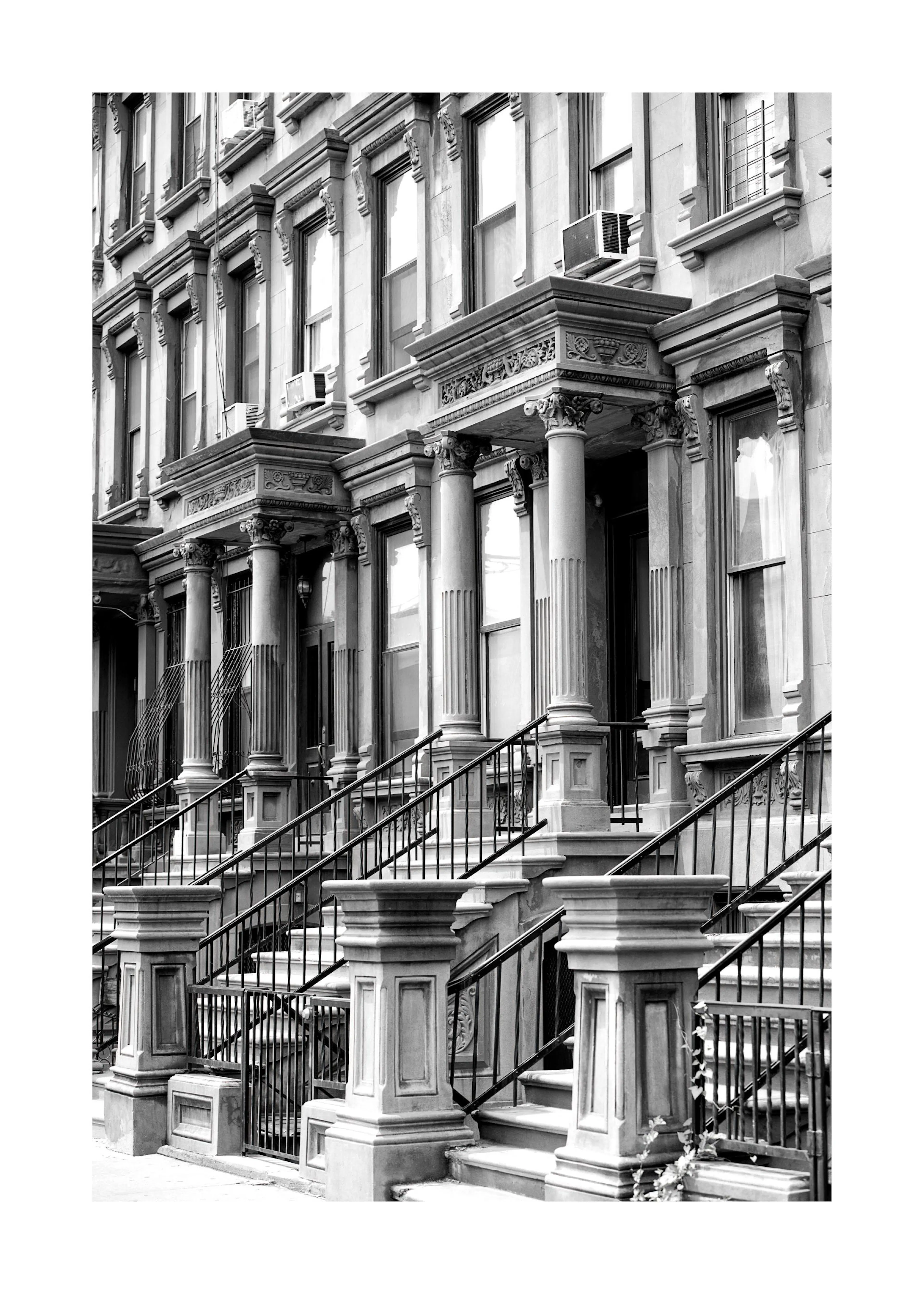 Poster en noir et blanc de façades de maisons de ville avec des escaliers, des balustrades et des piliers ornés.