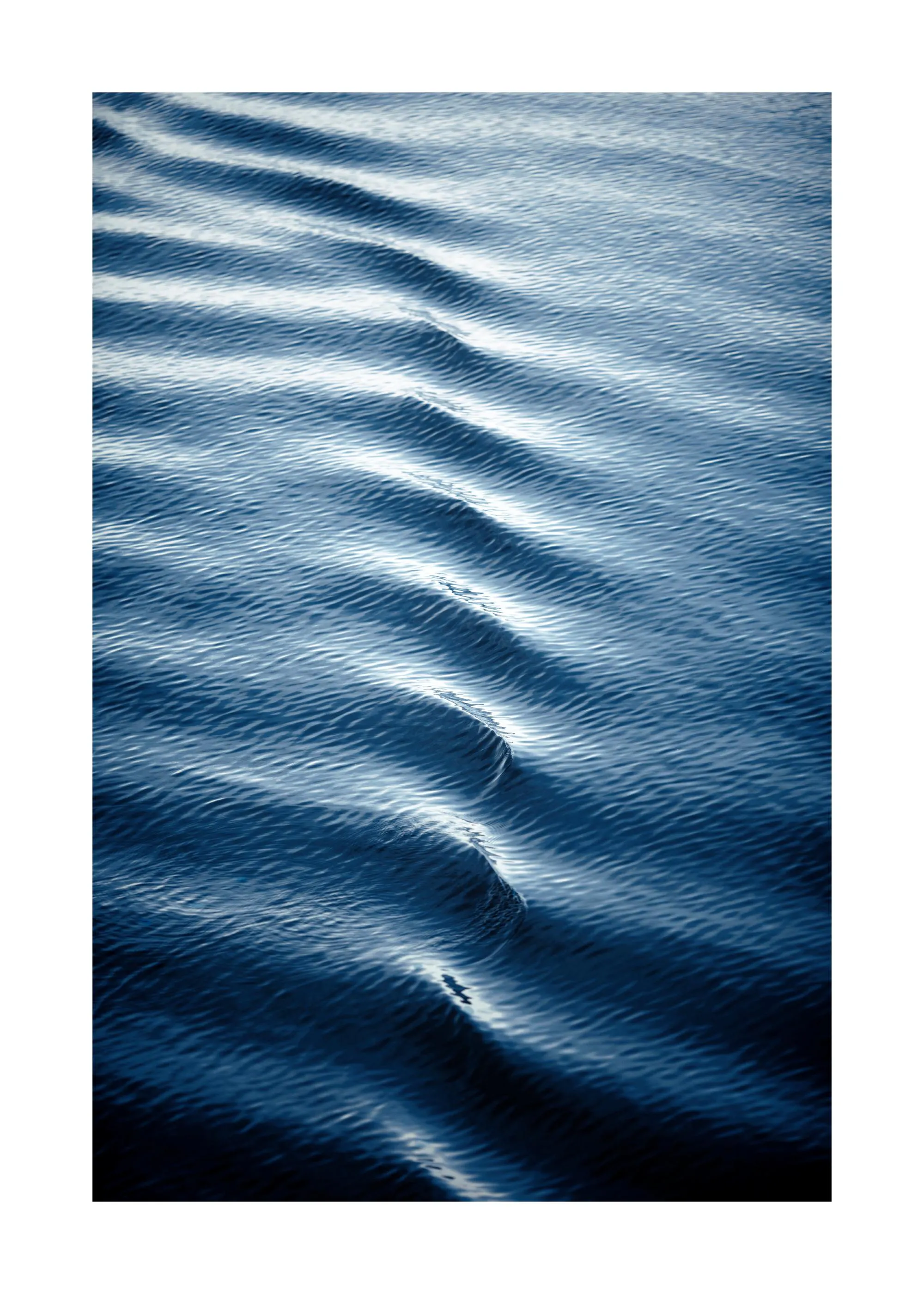 Plakát s detailním záběrem na tmavě modré vodní vlny s bílými odlesky.