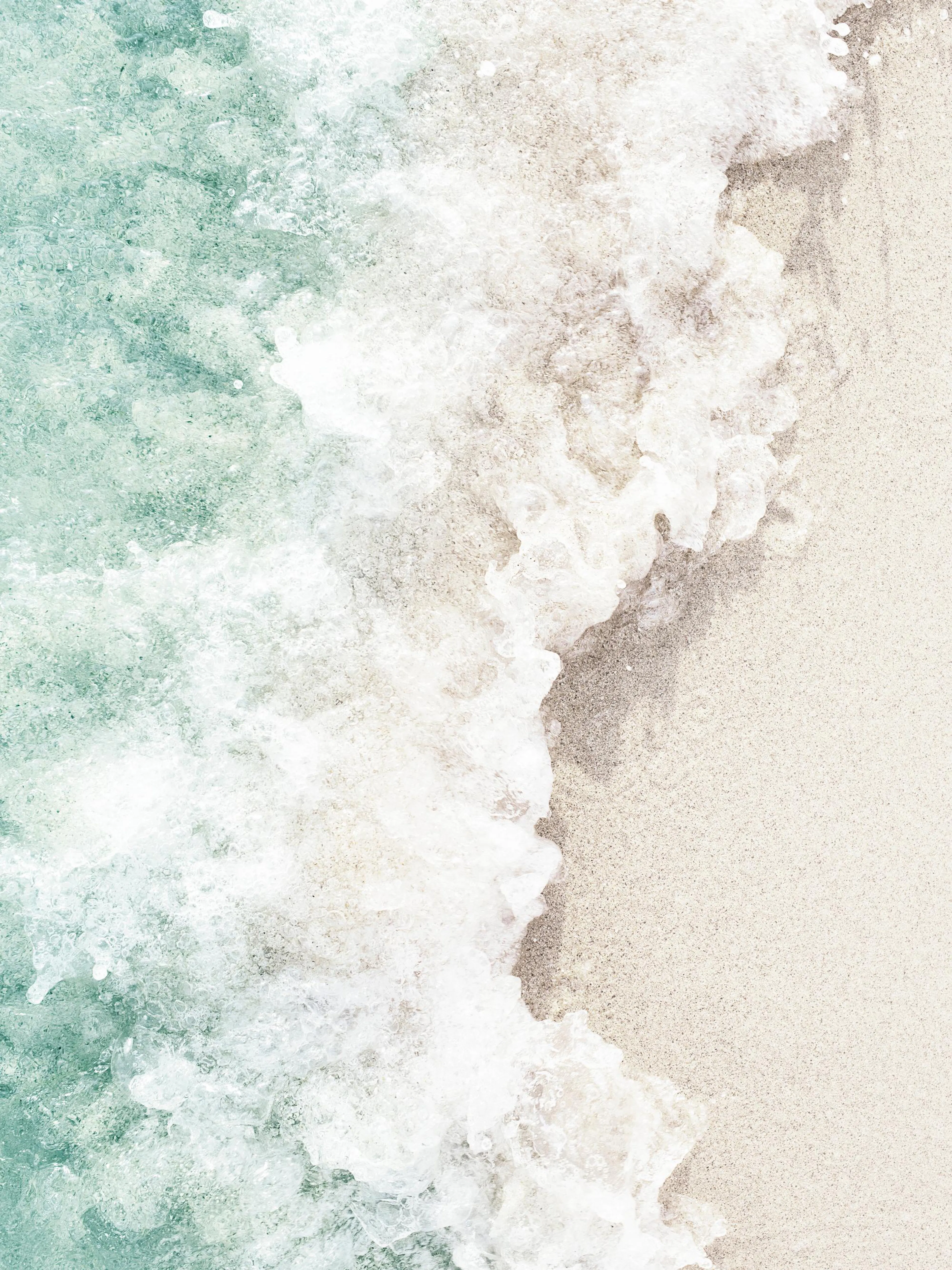 Un póster de olas turquesas y espumosas rompiendo sobre la arena clara de una playa.