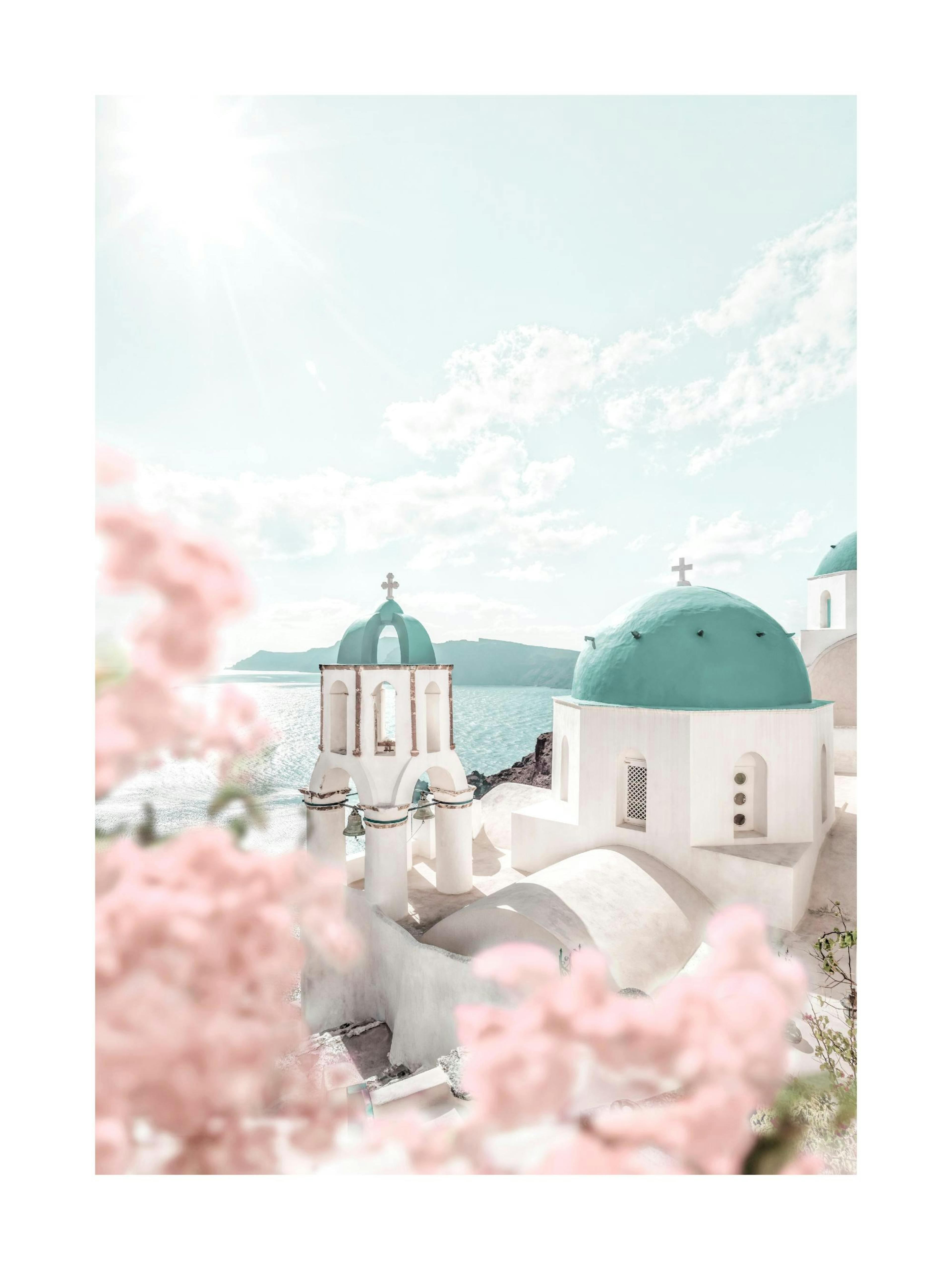 A poster featuring white buildings with teal domes and bell towers, with pink flowers in the foreground and a bright sea view in