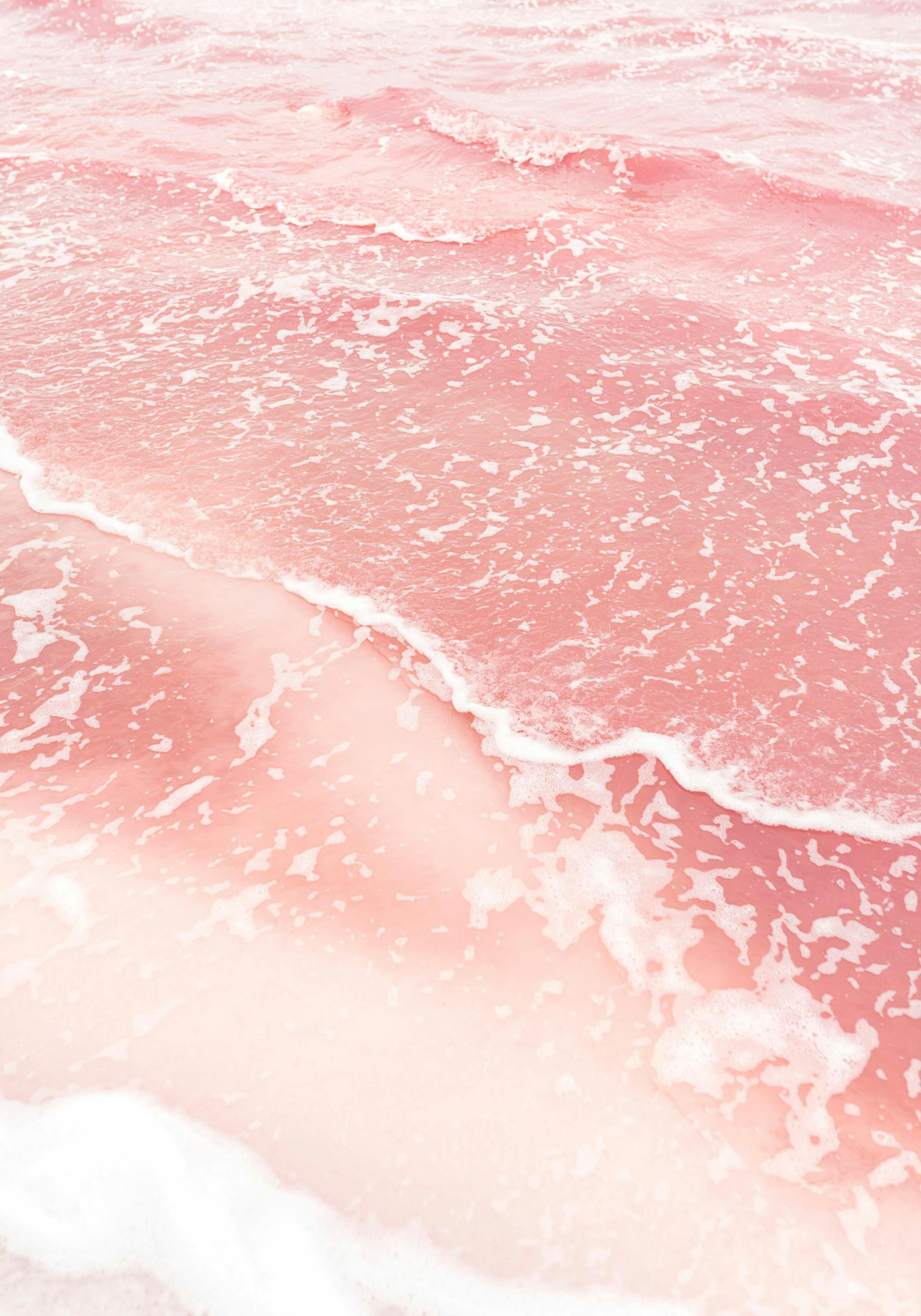 A poster featuring a close-up of pink ocean waves with white seafoam on the shore.