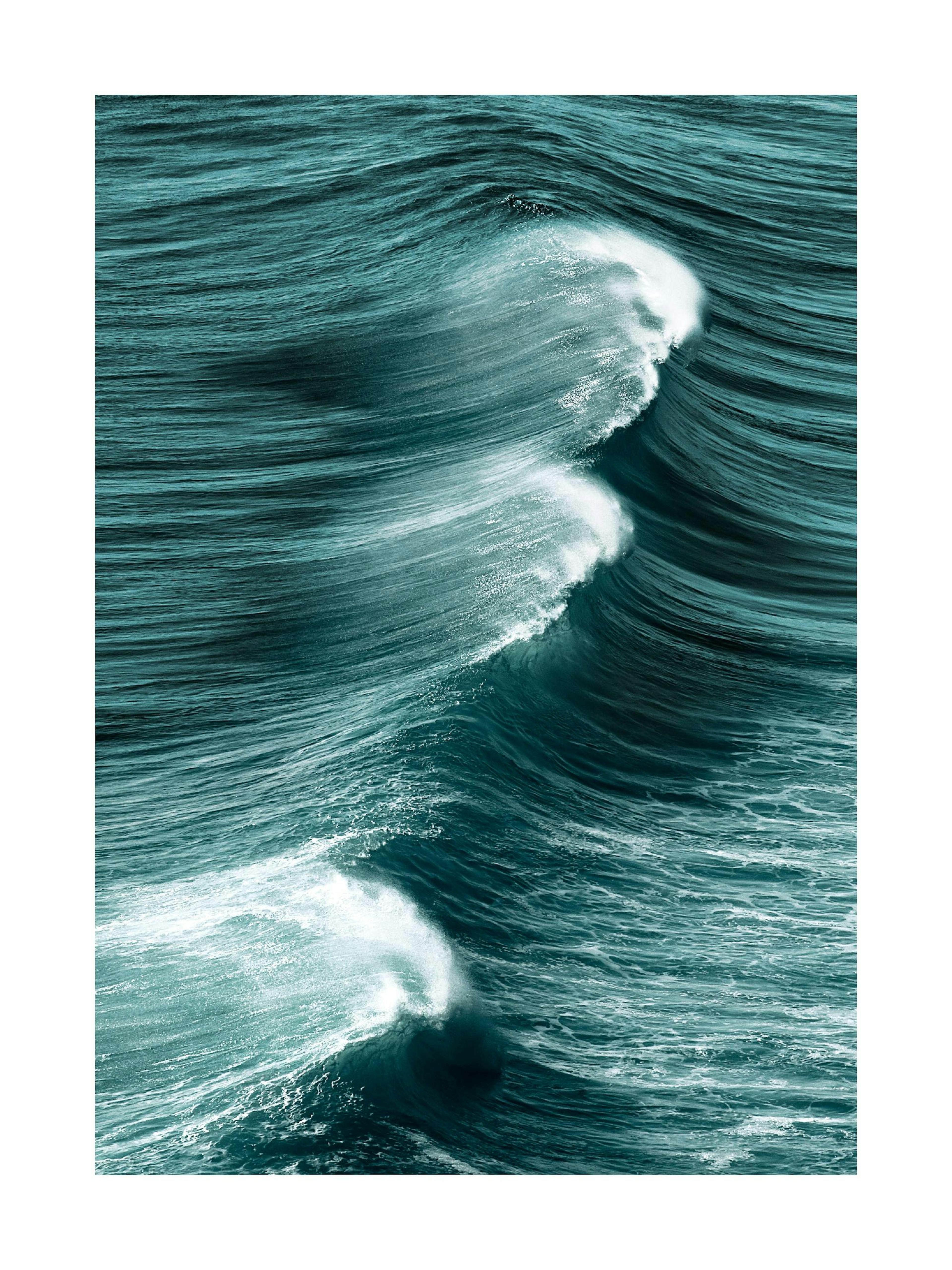 A poster featuring a large, powerful ocean wave with white foam cresting in deep teal and blue waters.