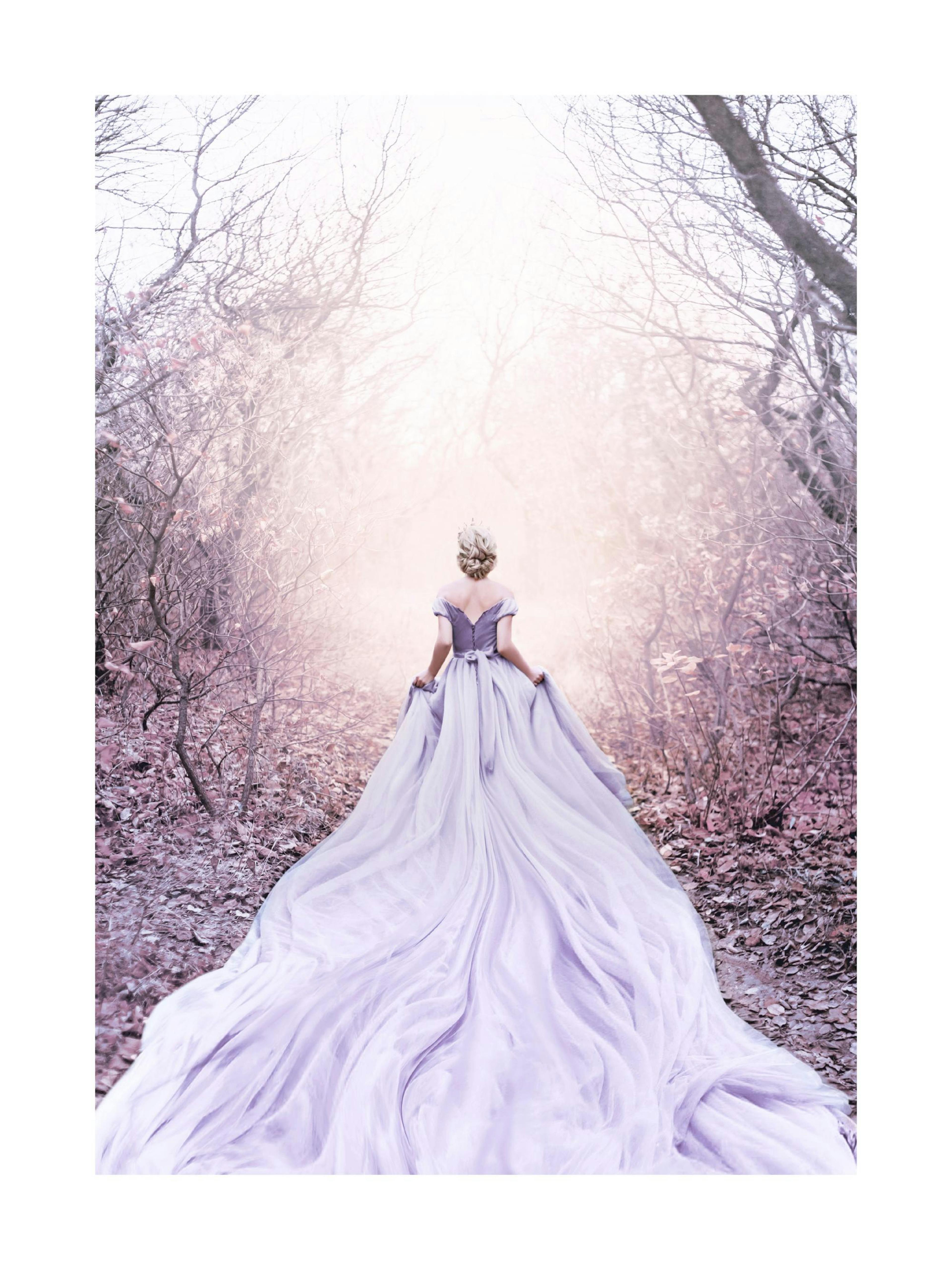 Plakat med en kvinde i en lilla kjole med slæb, der går ad en sti i en fortryllet skov med bare træer og lys for enden.
