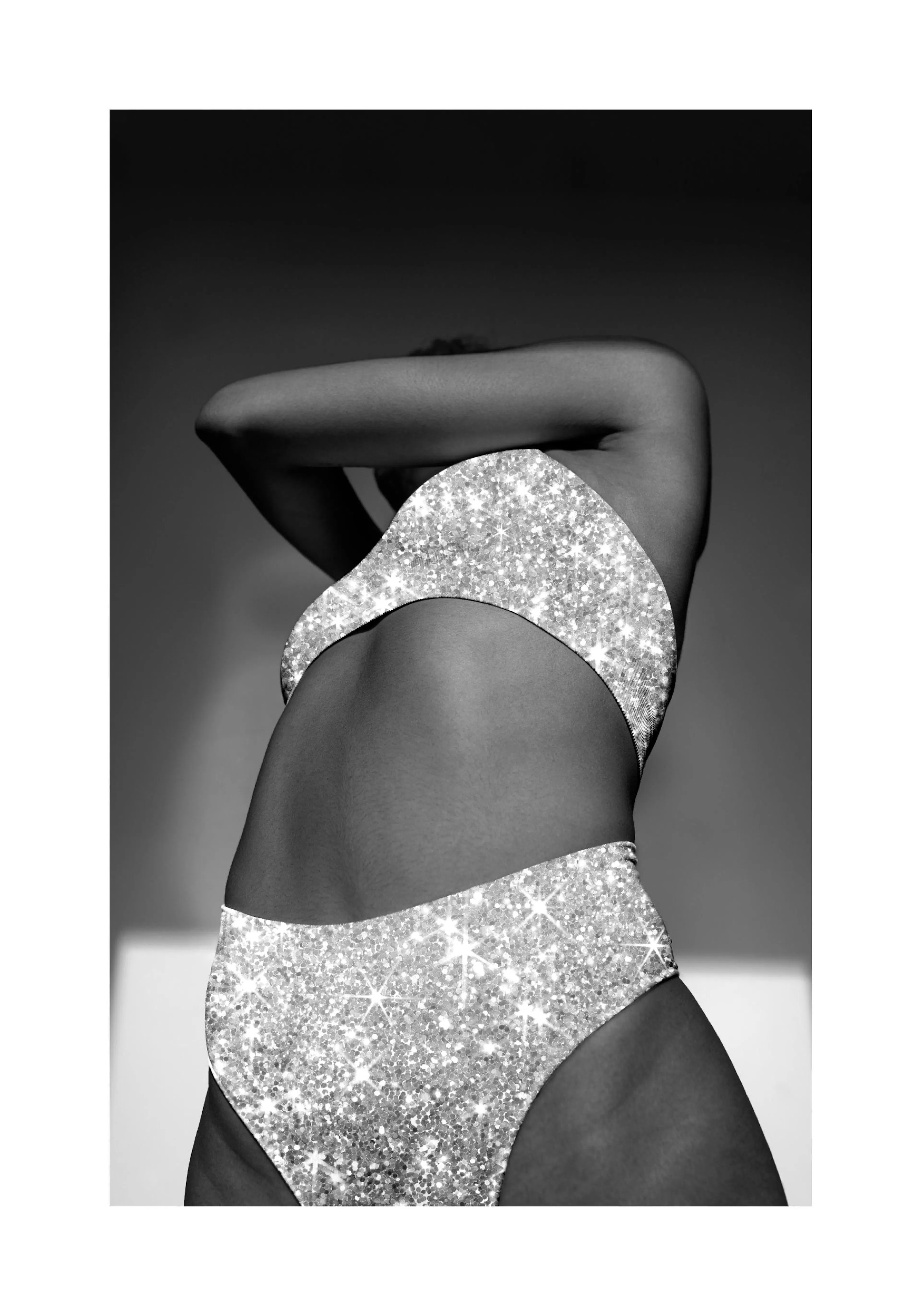 A black and white poster of a person from the back, wearing a sparkling bikini set.