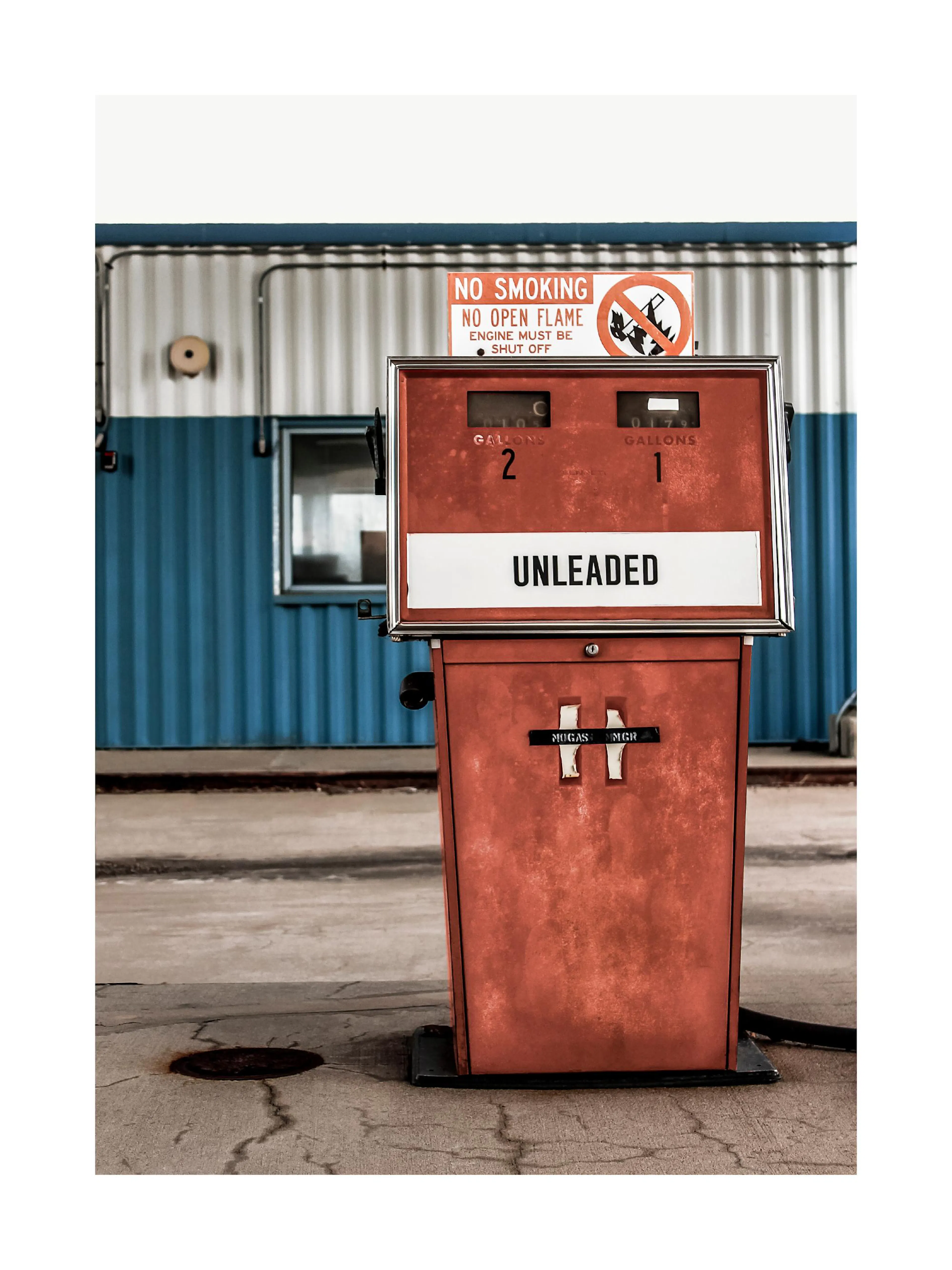 A poster featuring a close-up of a vintage red unleaded gas pump with peeling paint, set against a blue and grey corrugated wall