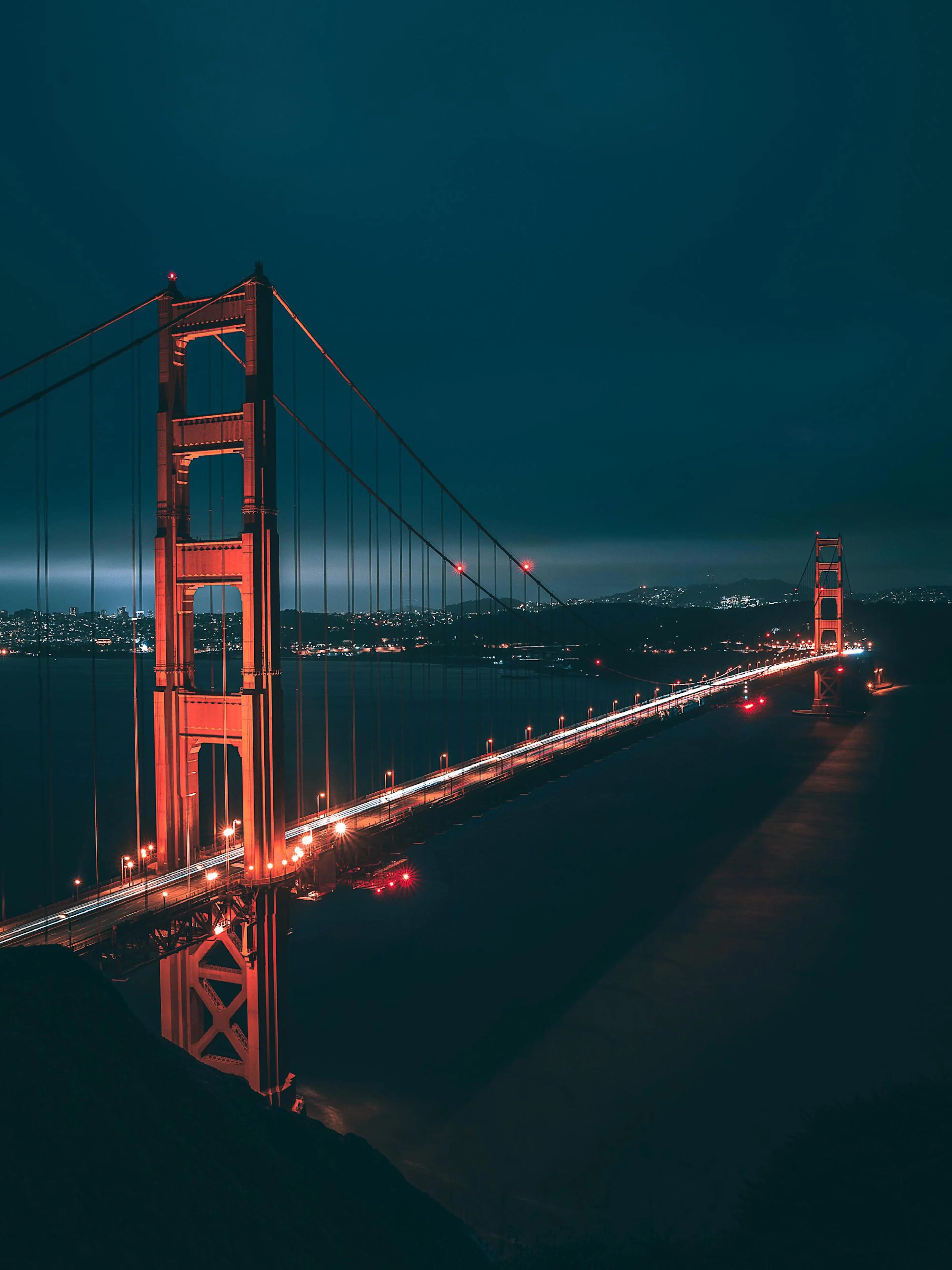 A poster featuring the Golden Gate Bridge lit up at night, with light trails from cars and a dark sky.