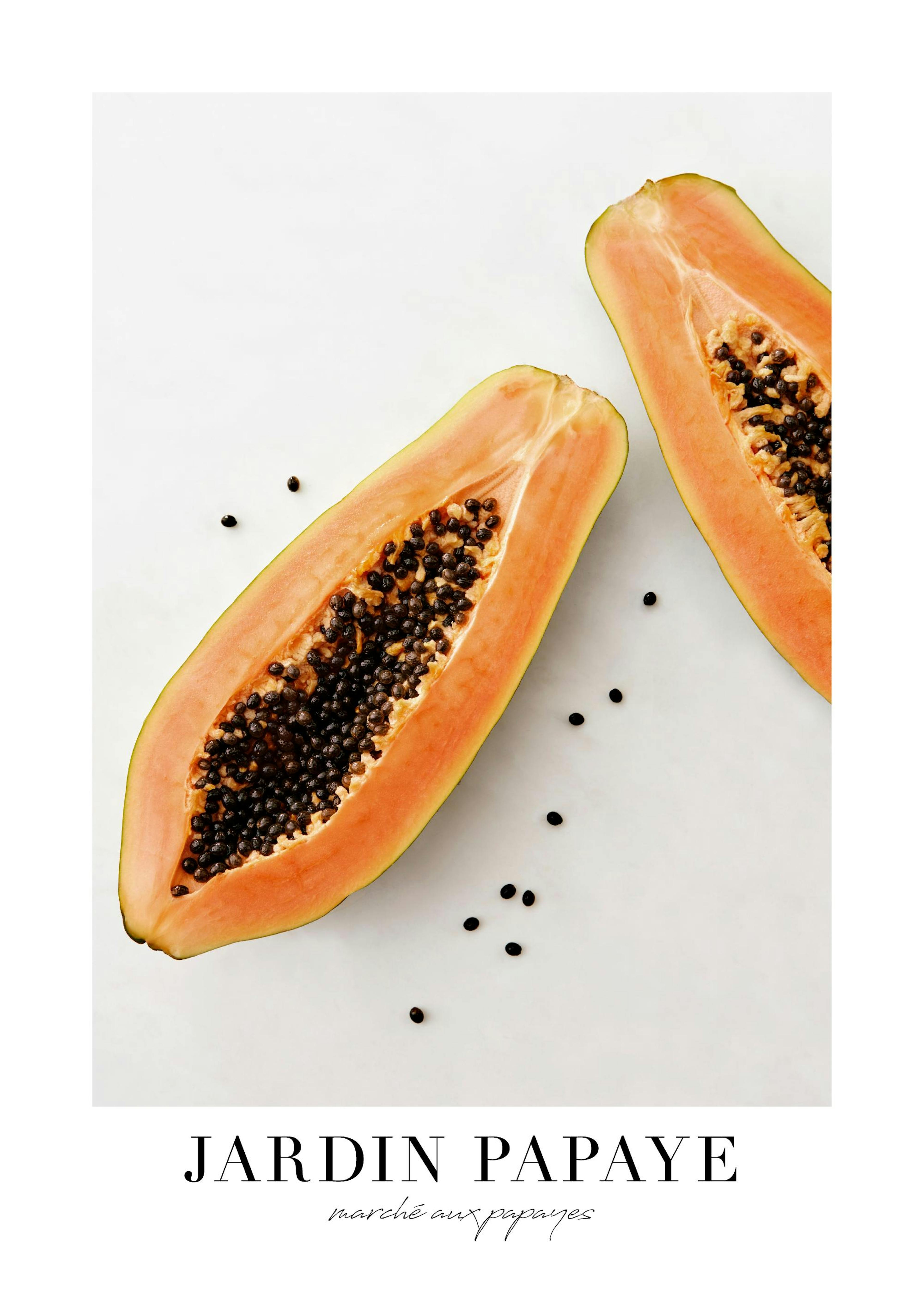 A poster featuring two halves of a papaya with seeds on a light background, hanging above a round table with a book and mug.