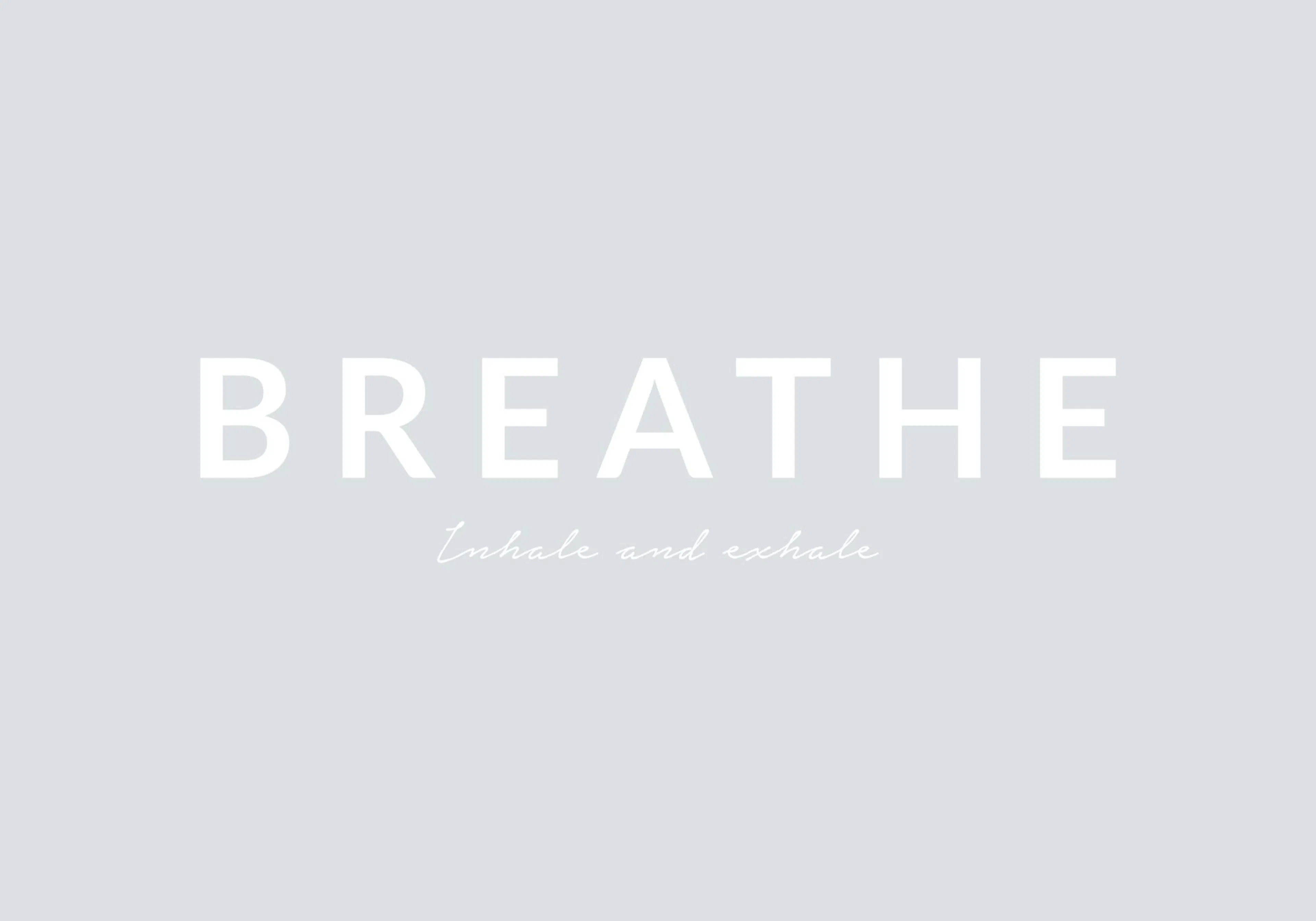 A calming poster with the word BREATHE in large white letters above inhale and exhale on a light grey background.
