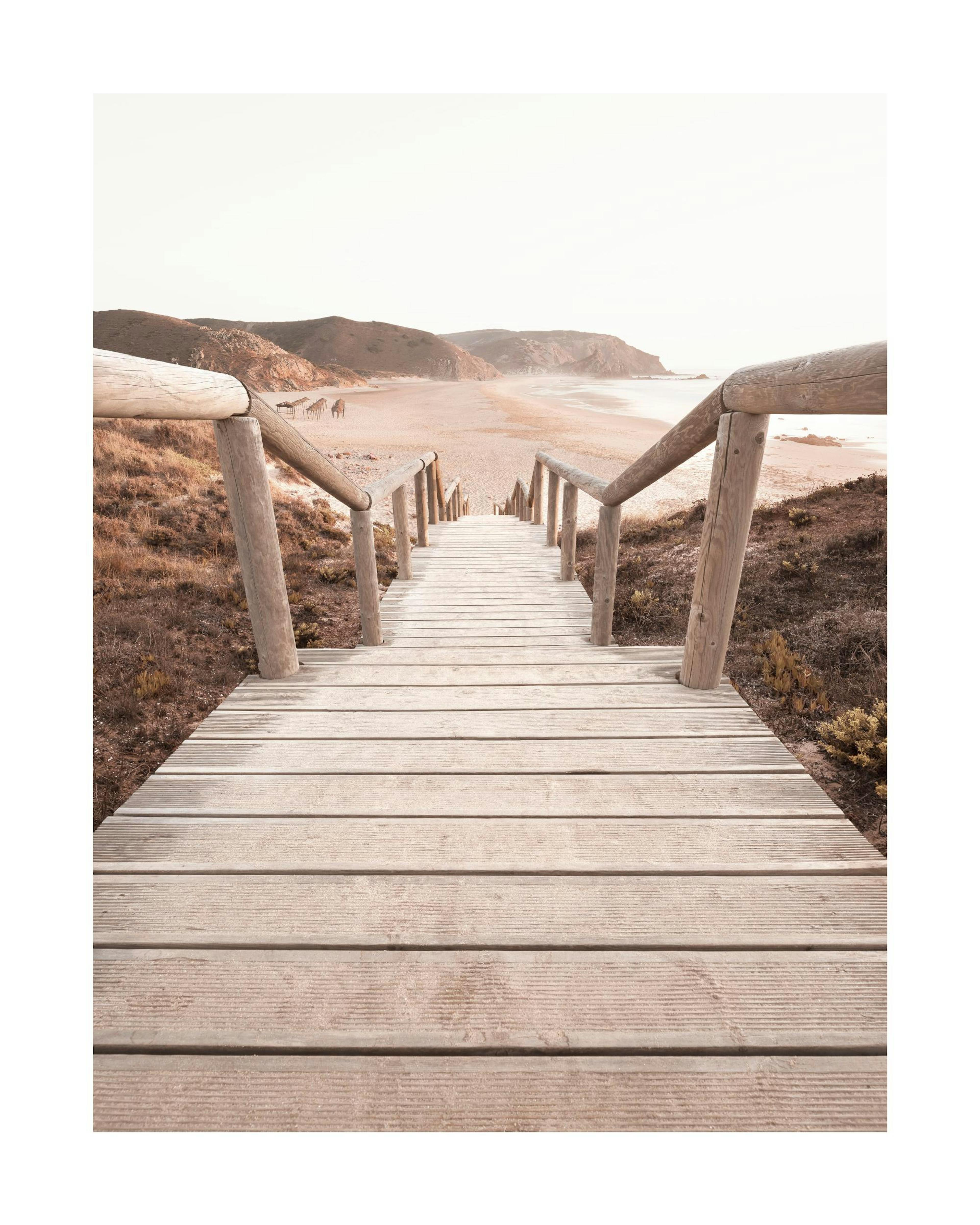A poster featuring a wooden boardwalk leading down to a sandy beach with hills and calm ocean waves in the distance.