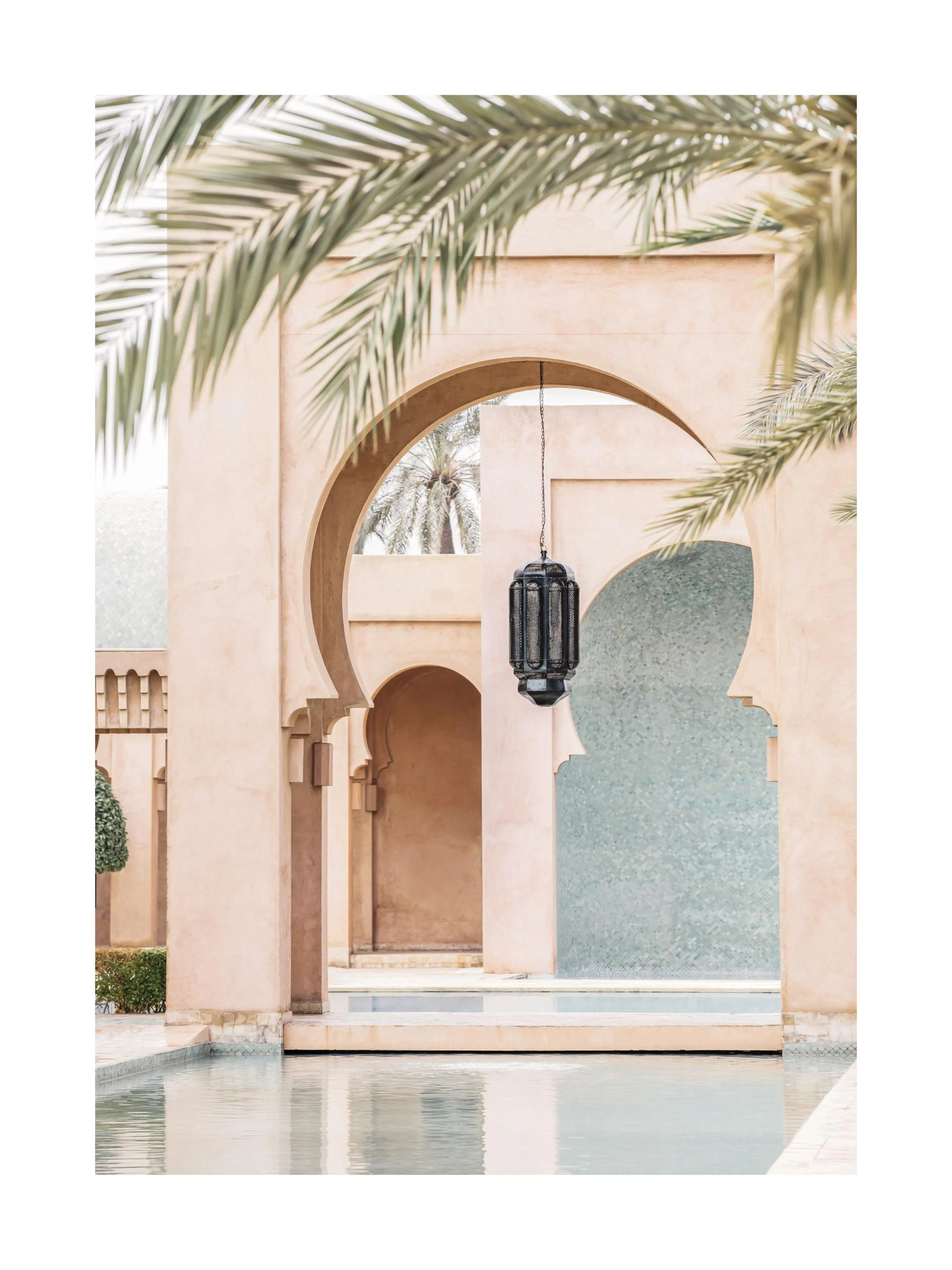 A poster featuring a Moroccan-style archway over a serene pool, with a hanging lantern and palm leaves visible.