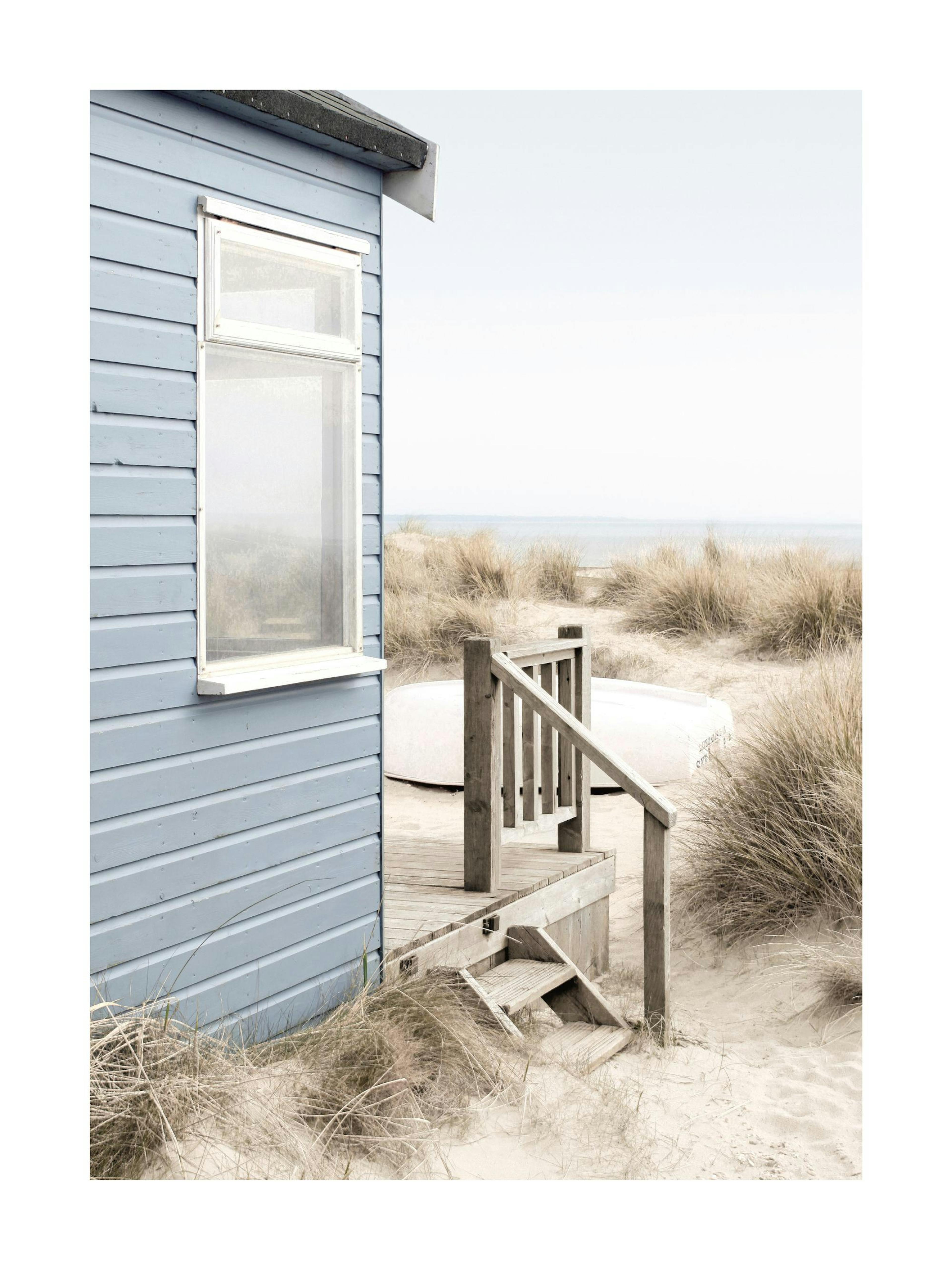 A poster featuring a light blue beach hut with a wooden deck and steps on a sandy beach with tall grasses and the ocean in the b