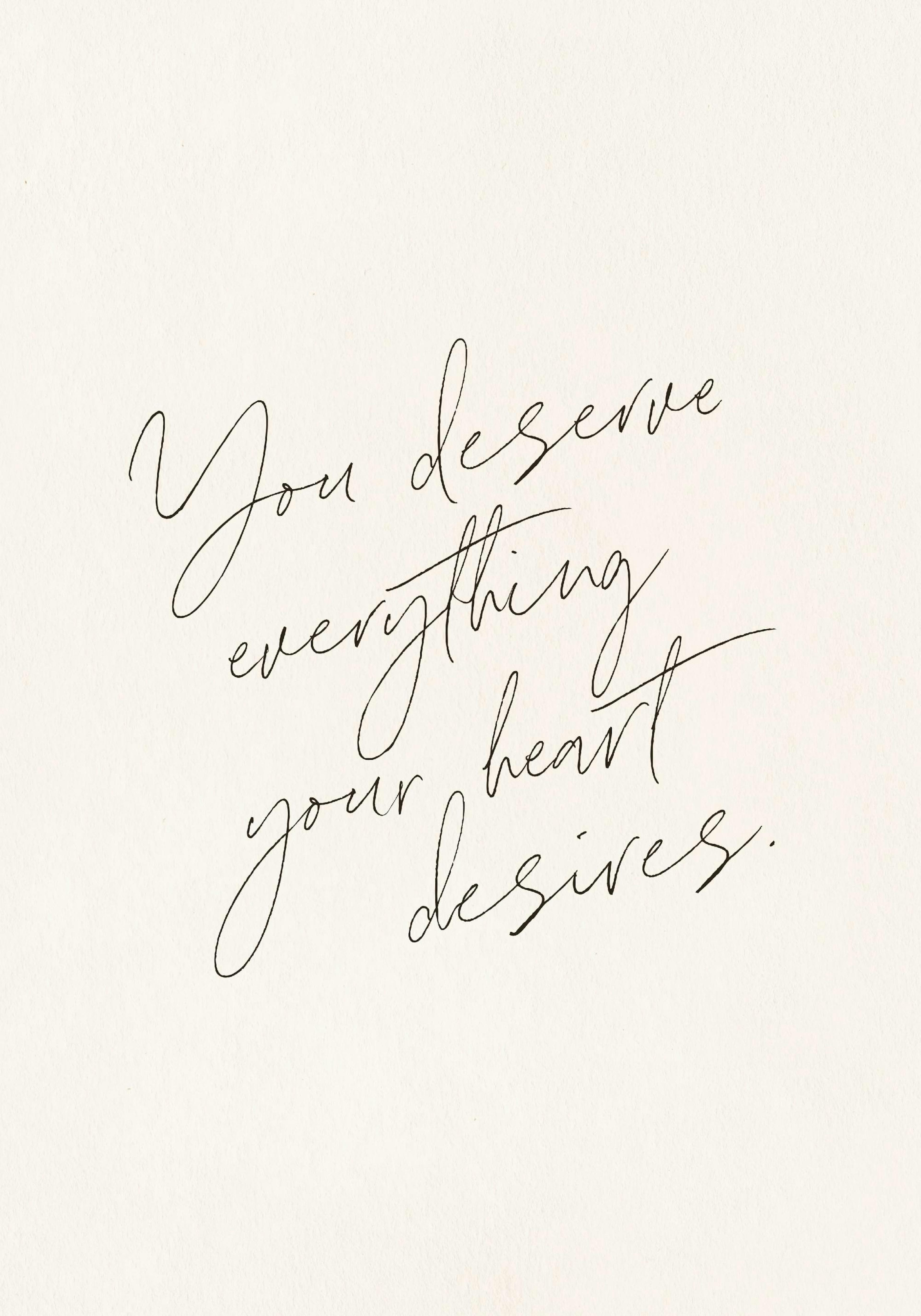 Plakat z motywującym napisem You deserve everything your heart desires w eleganckim, czarnym piśmie na beżowym tle.