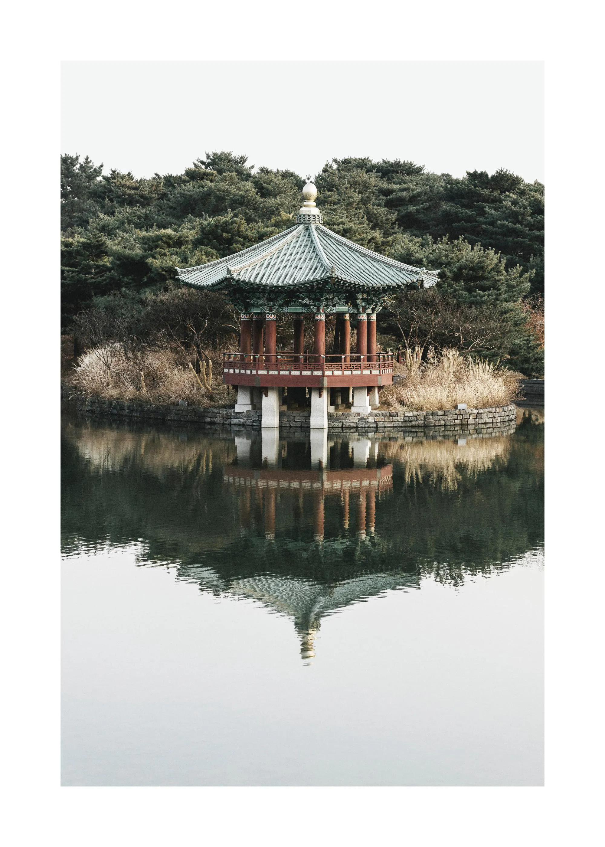 Een poster van een traditionele Koreaanse pagode op een eiland in een serene vijver met weerspiegeling.
