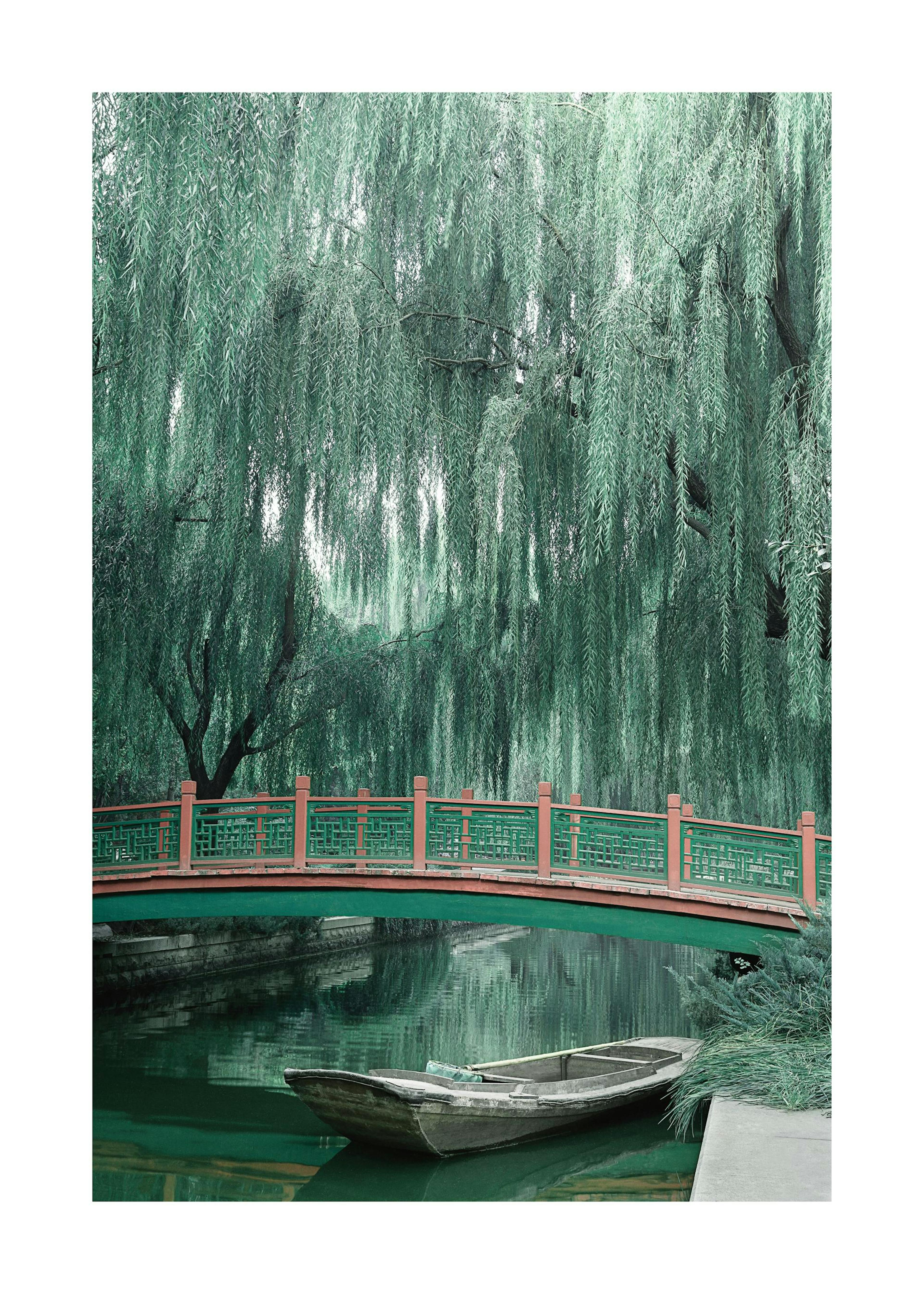 Poster dun pont rouge et vert sur un canal avec un saule pleureur luxuriant et une barque en bois.