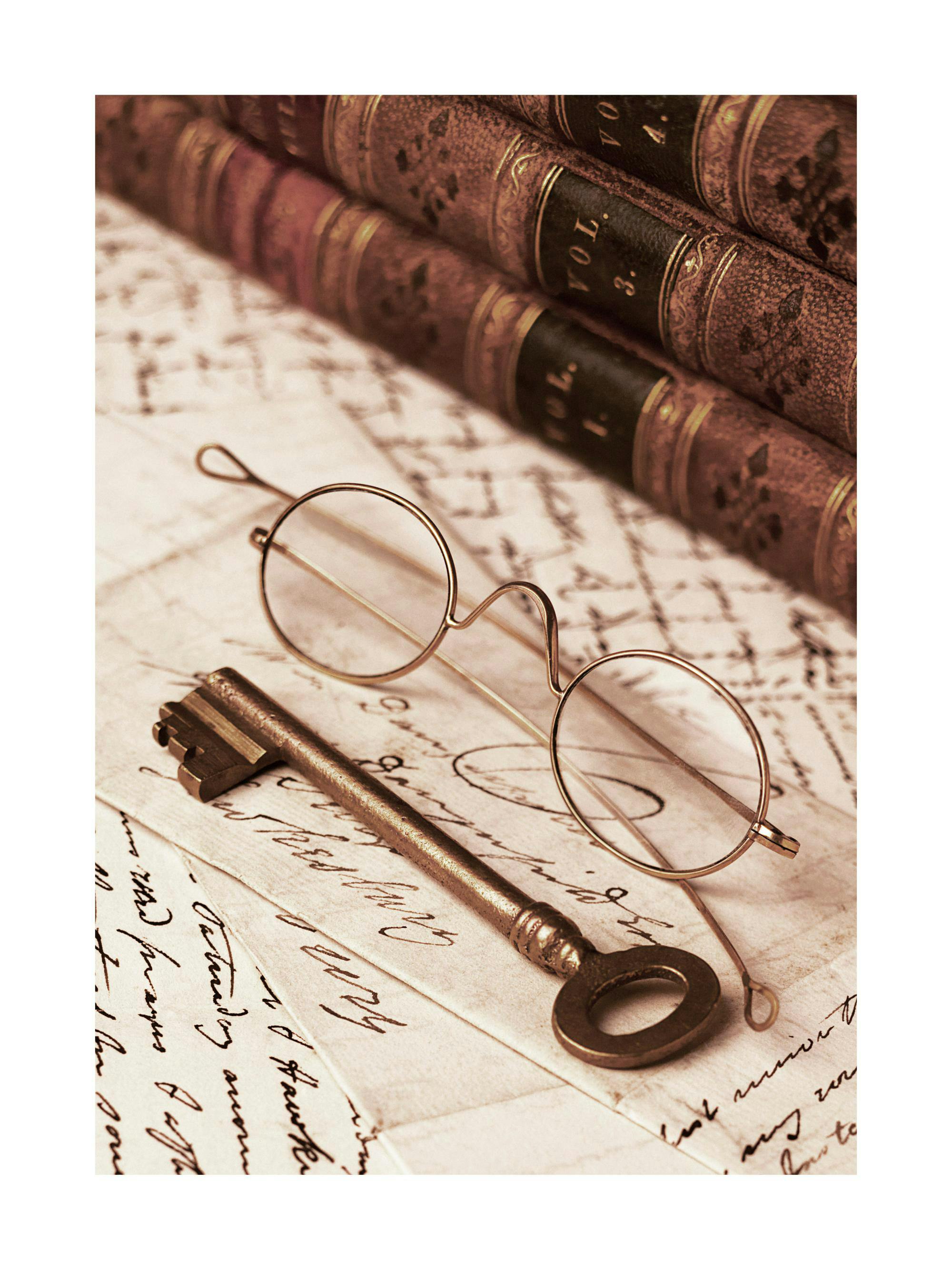 A sepia-toned poster featuring vintage books, an antique key, and spectacles on handwritten letters.