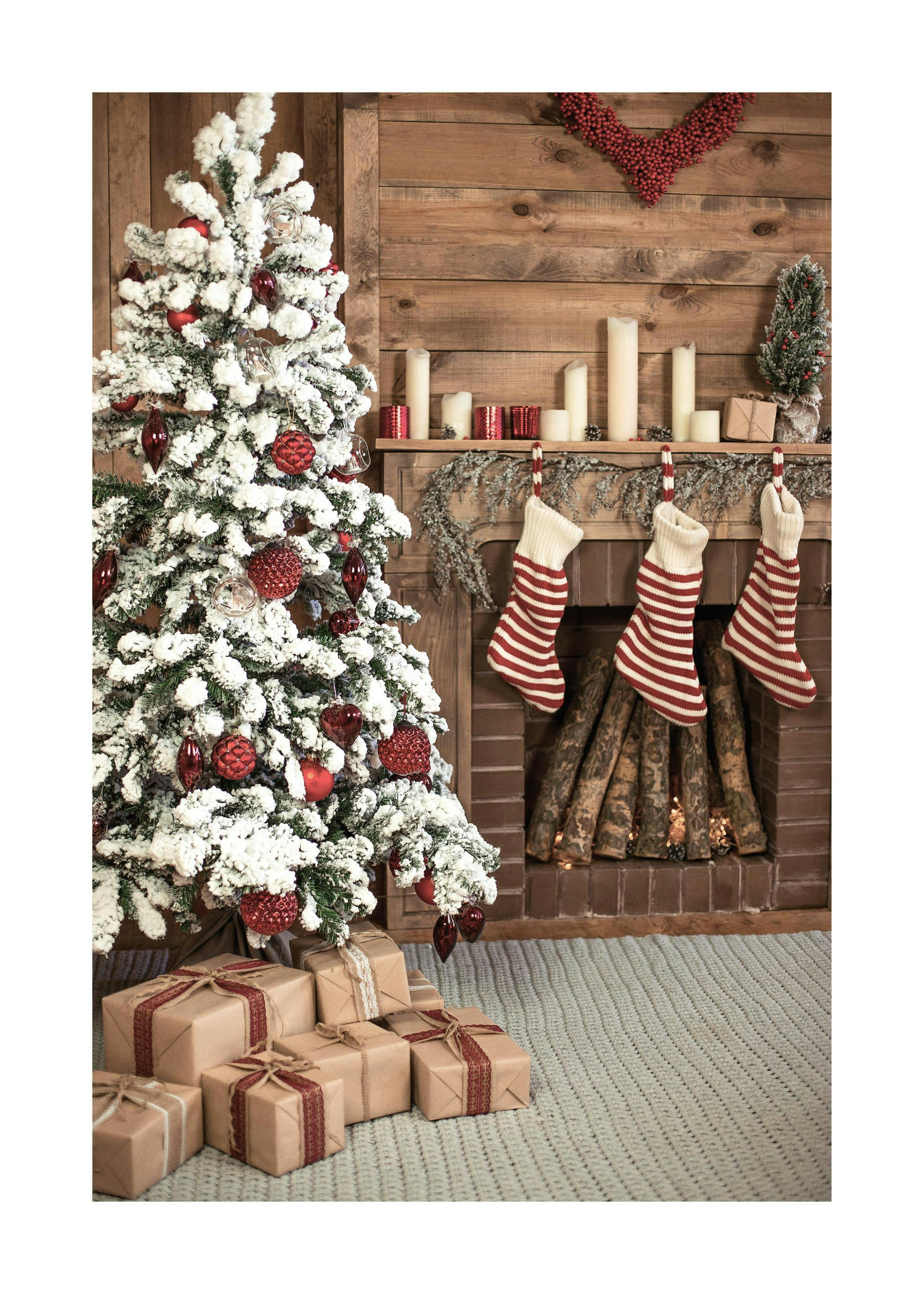 Ein Poster eines geschmückten Weihnachtsbaums mit roten Kugeln und Geschenken vor einem Kamin mit roten Weihnachtssocken.