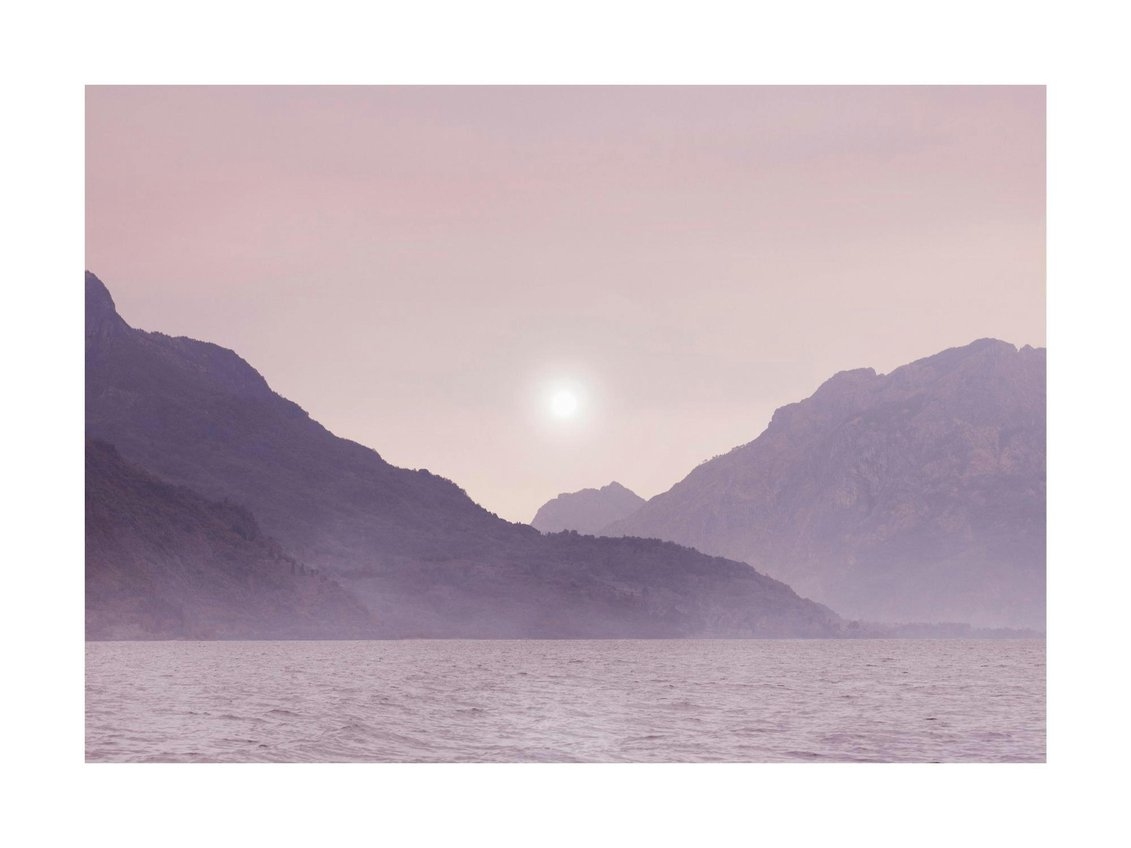 A poster featuring a tranquil lake at dusk, with purple mountains silhouetted against a dusty pink sky.