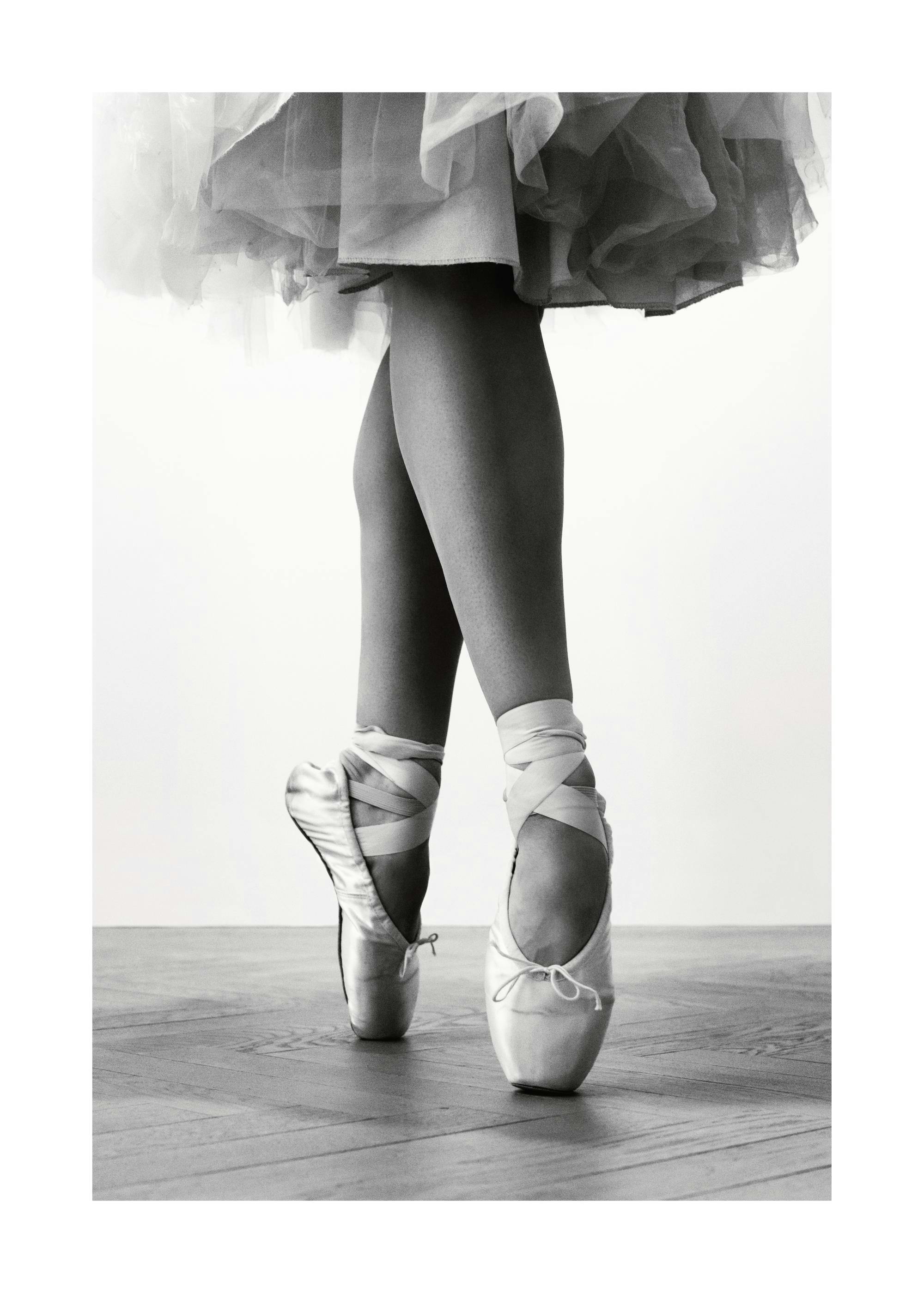 Poster noir et blanc des jambes dune ballerine en tutu et chaussons de danse sur pointe.